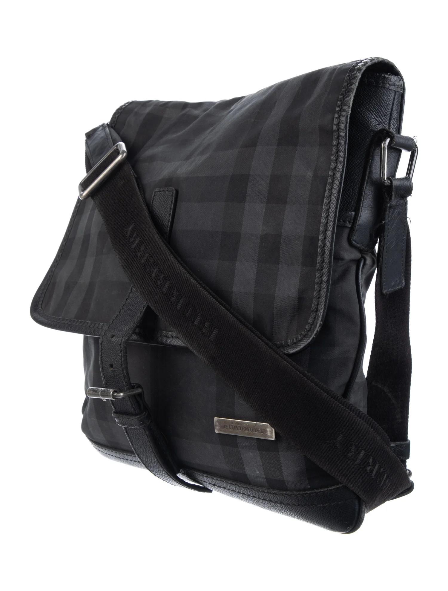 BURBERRY BLACK NOVA CHECK NYLON MESSENGER BAG

This Burberry messenger bag is constructed from black nylon featuring the signature Nova Check plaid print, complemented by leather trim and ruthenium (gunmetal) hardware. It includes a single