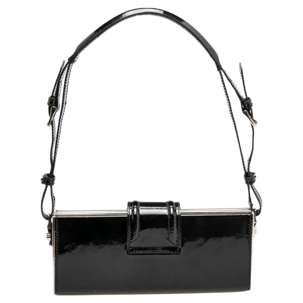 Pretty and poised, this pochette from the House of Burberry is a luxe accessory you need to own today! It has been designed using black patent leather on the exterior with silver-toned decorative elements accentuating its appearance. It comes with a