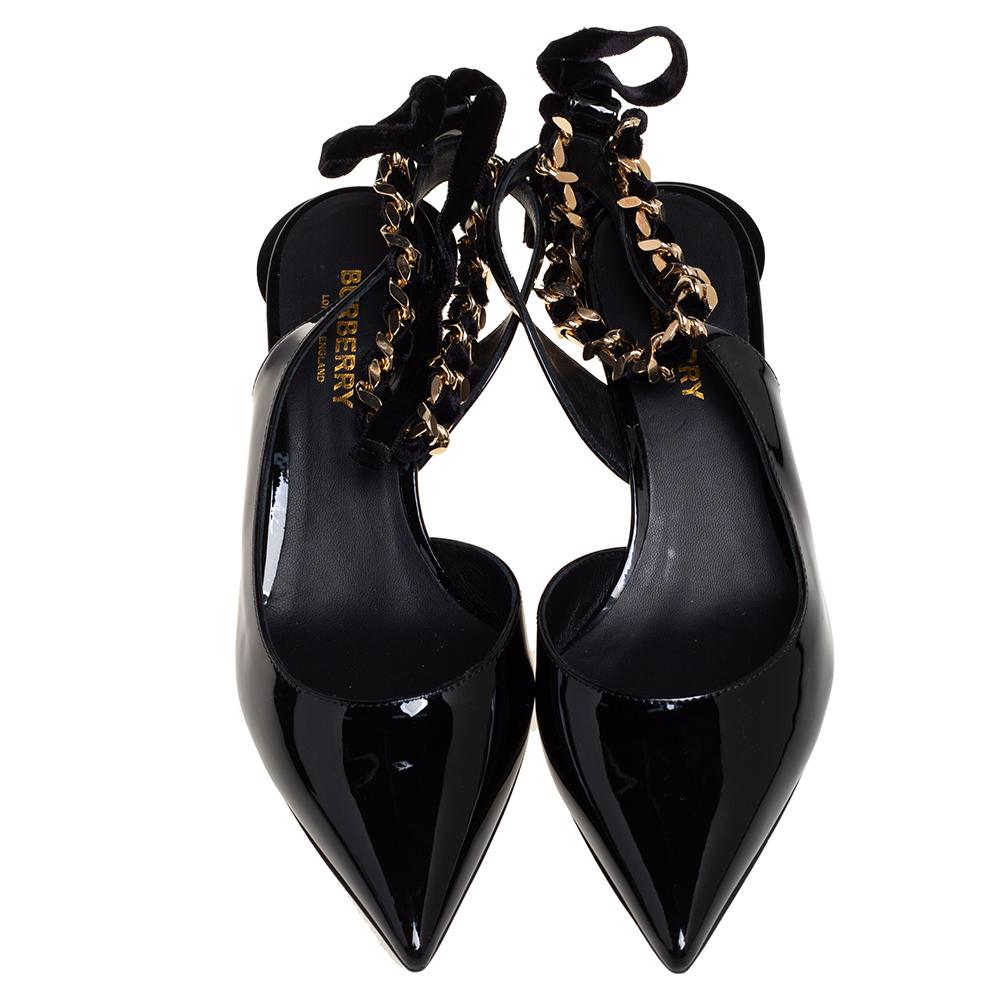 Feminine, edgy, and comfortable, these Burberry pumps are an example of the label's refined charm. Crafted from patent leather in a black shade, they come in a pointed-toe silhouette adorned with ankle wraps accented with chain detailing. These