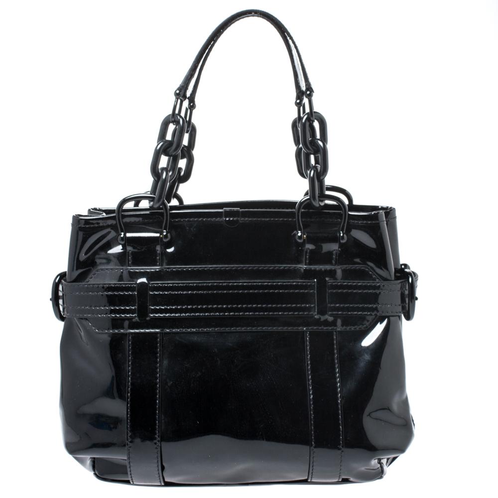 This tote by Burberry makes an ultimate style statement. Crafted from patent leather, this tote can effortlessly hold further than just essentials. The bag is held by two chain handles and the interior is lined with fabric.

Includes: The Luxury