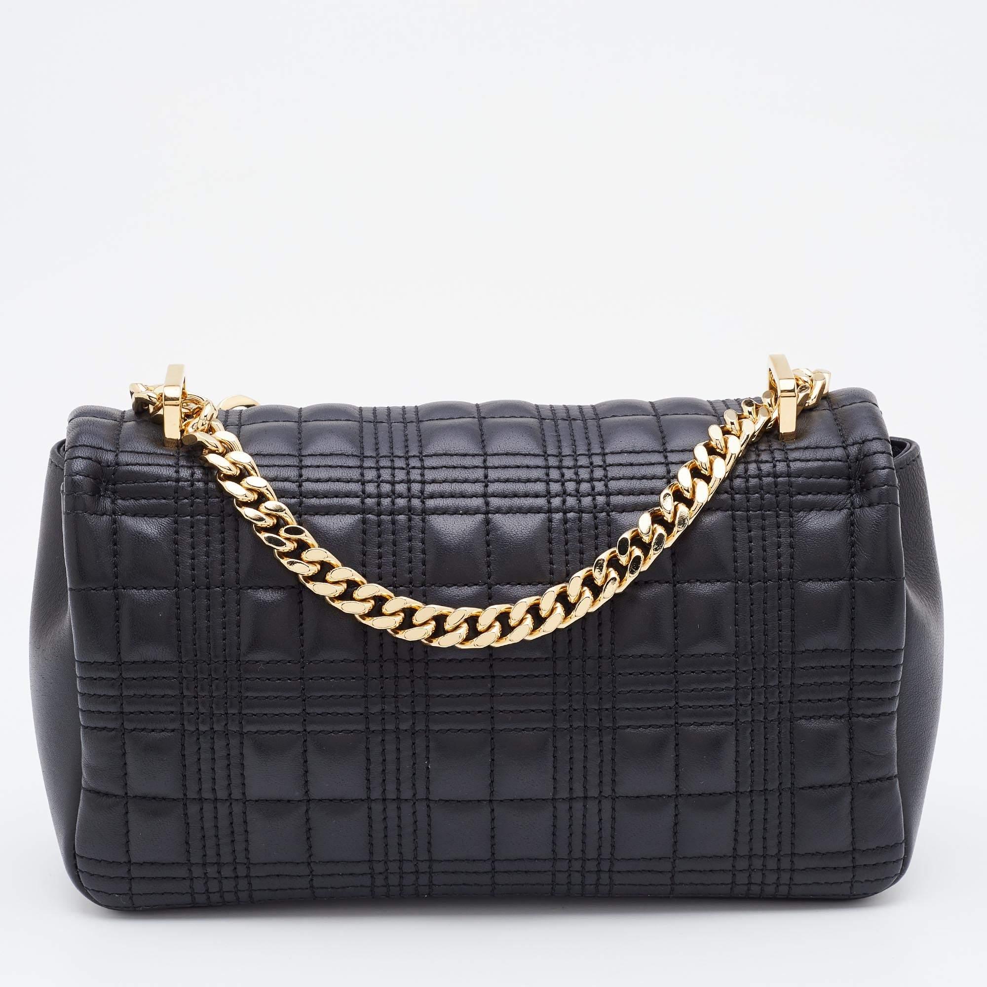 This Lola shoulder bag from Burberry does complete justice to the brand's timeless aesthetic. Externally, it is made using black and white quilted leather with a gold-tone TB accent decorating the front. It features a chain shoulder strap and an