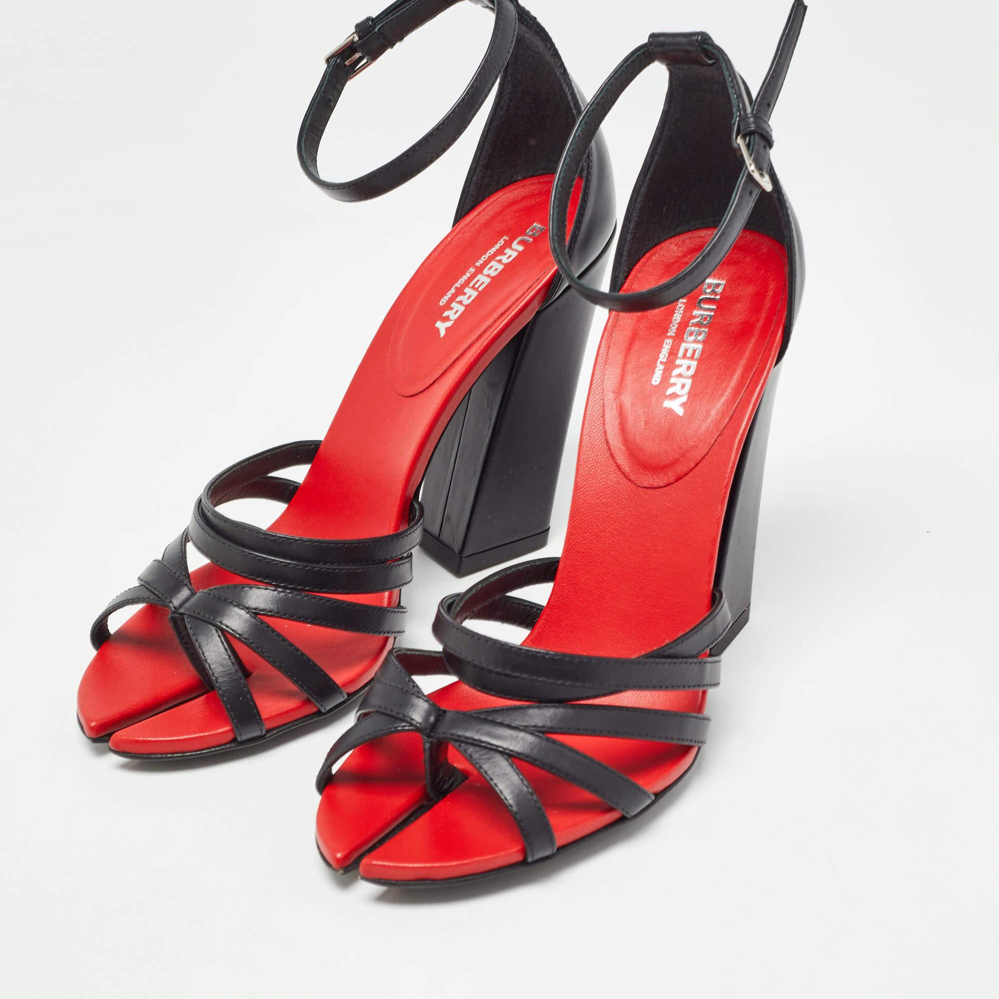 Diese Sandalen von Burberry sind aus schwarzem Leder gefertigt und mit Cutouts an den Zehen, rotem Lederfutter, Riemchen und 10 cm hohen Blockabsätzen versehen. Sie sind mit Schnallenverschlüssen am Knöchel ausgestattet.
