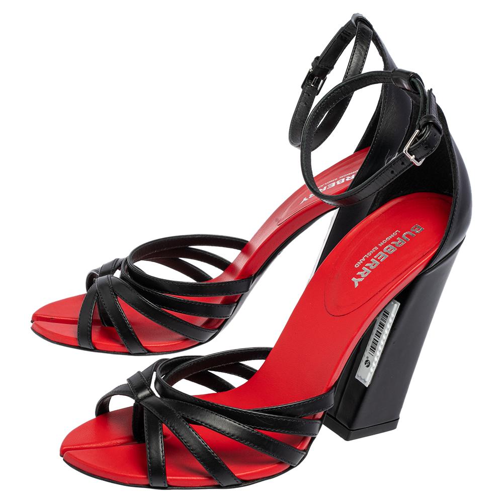 These sandals from Burberry are edgy and sleek at the same time. They have been crafted from black leather and designed beautifully with strappy on the toes, red leather lining, and block heels. They are made complete with buckled ankle strap