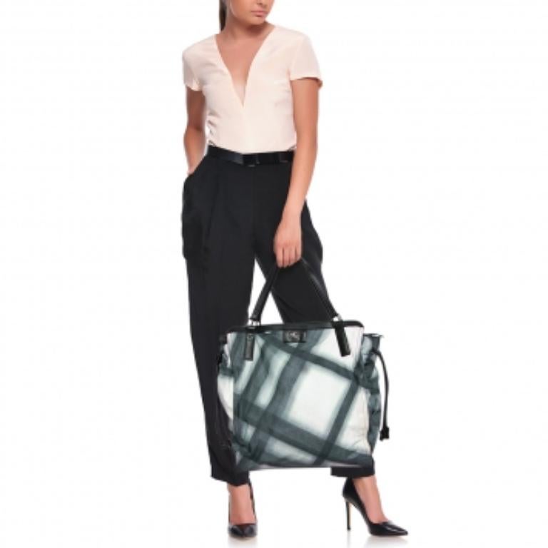 This classy and praiseworthy Buckleigh tote from Burberry is a must have. It is crafted from leather and Smoked check nylon, featuring dual top flat handles and a zip closure. This tote reveals a nylon-lined interior with brand detailing. It is