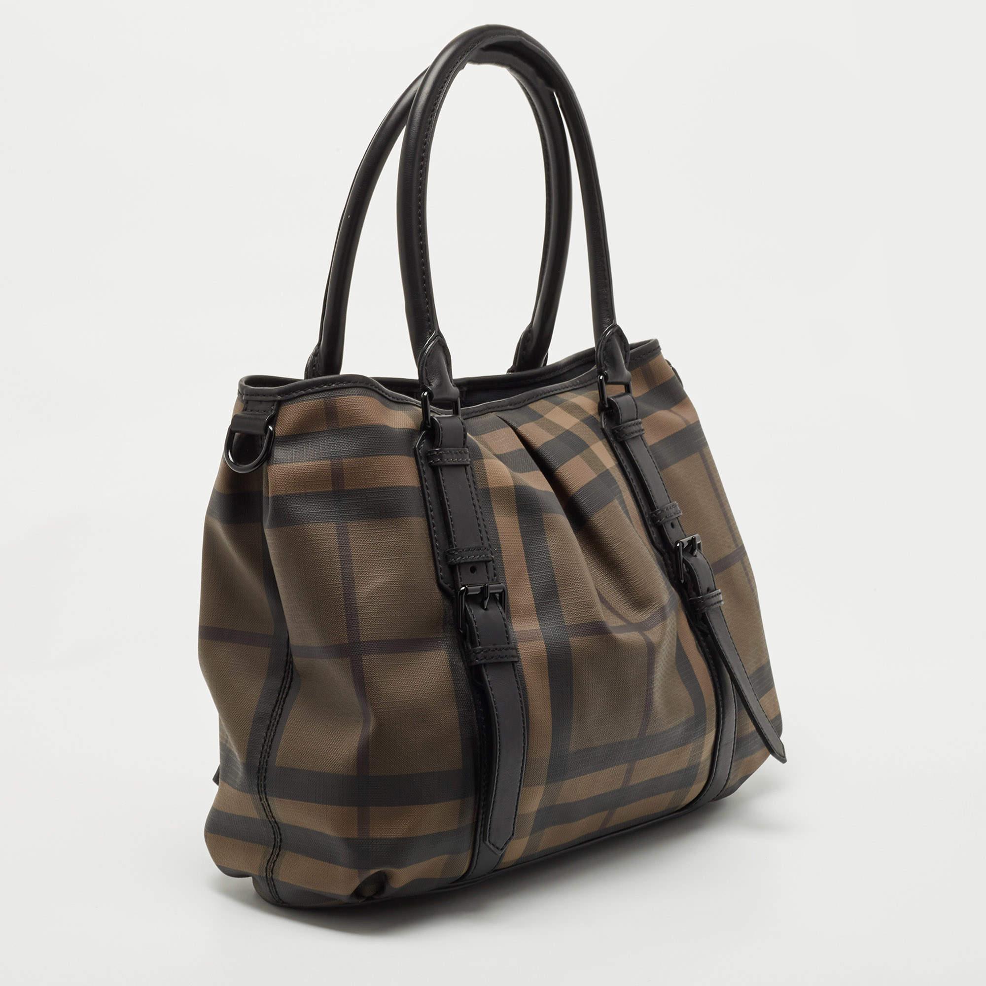 Burberry's Lowry tote deserves to be in every fashionista's bag collection! Meticulously crafted from PVC and leather the bag features a lovely cartridge pleat exterior. The bag is equipped with a detachable shoulder strap, protective metal feet at