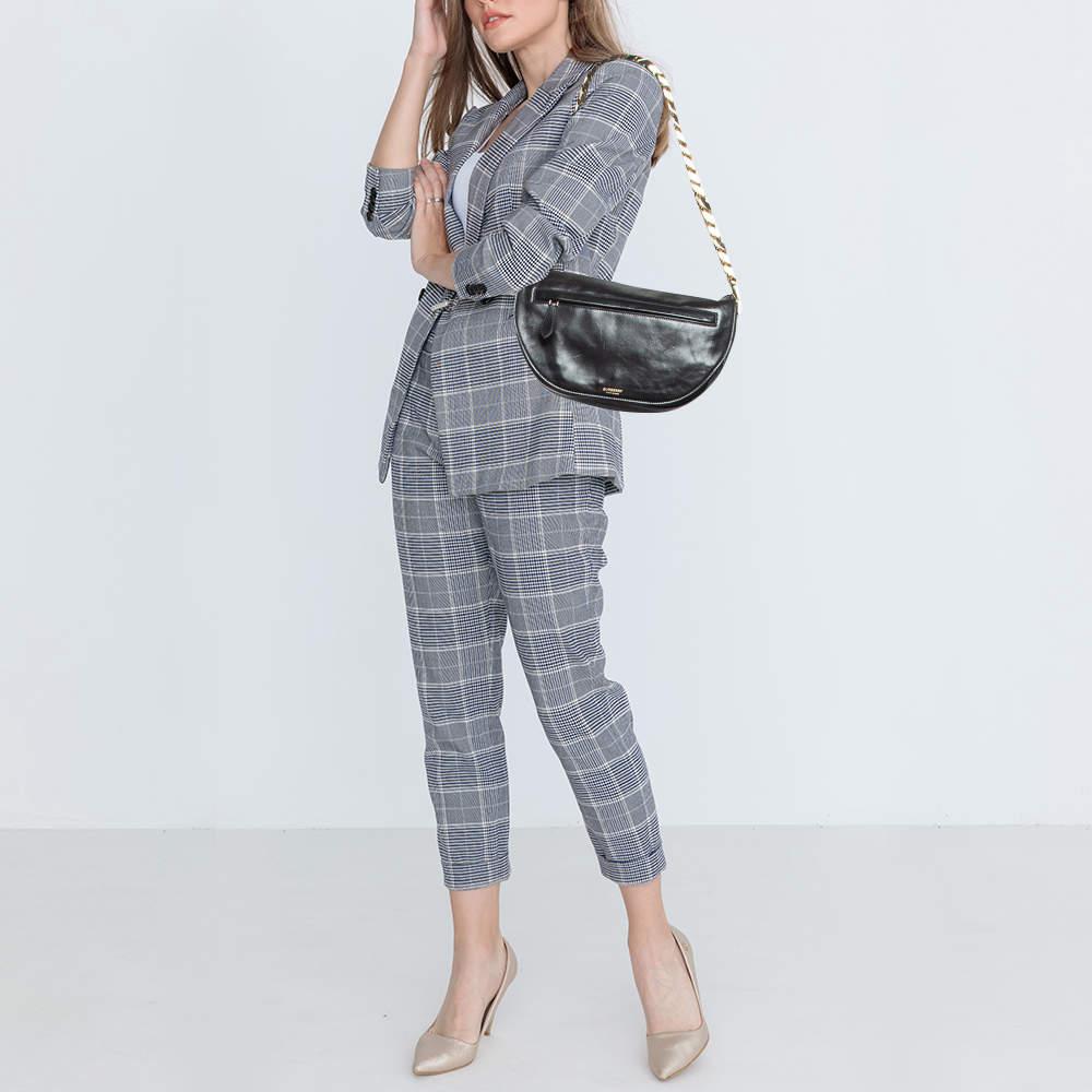 Con una forma arquitectónica, este bolso Burberry Olympia se asemeja a la luna creciente. La firma de la marca en la parte delantera contribuye a su identificación instantánea y se puede llevar cómodamente con una correa para el hombro. Capturando