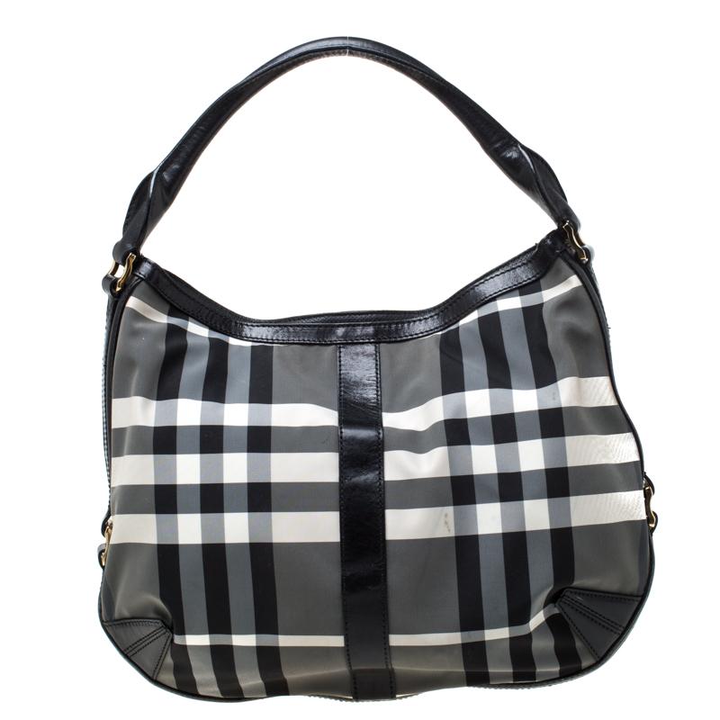 Sophisticated and easy to carry, this black and white hobo from Burberry is a must-buy! It is crafted from nylon and comes equipped with a leather handle strap and a top zipper that opens to a spacious interior that can easily hold all your daily