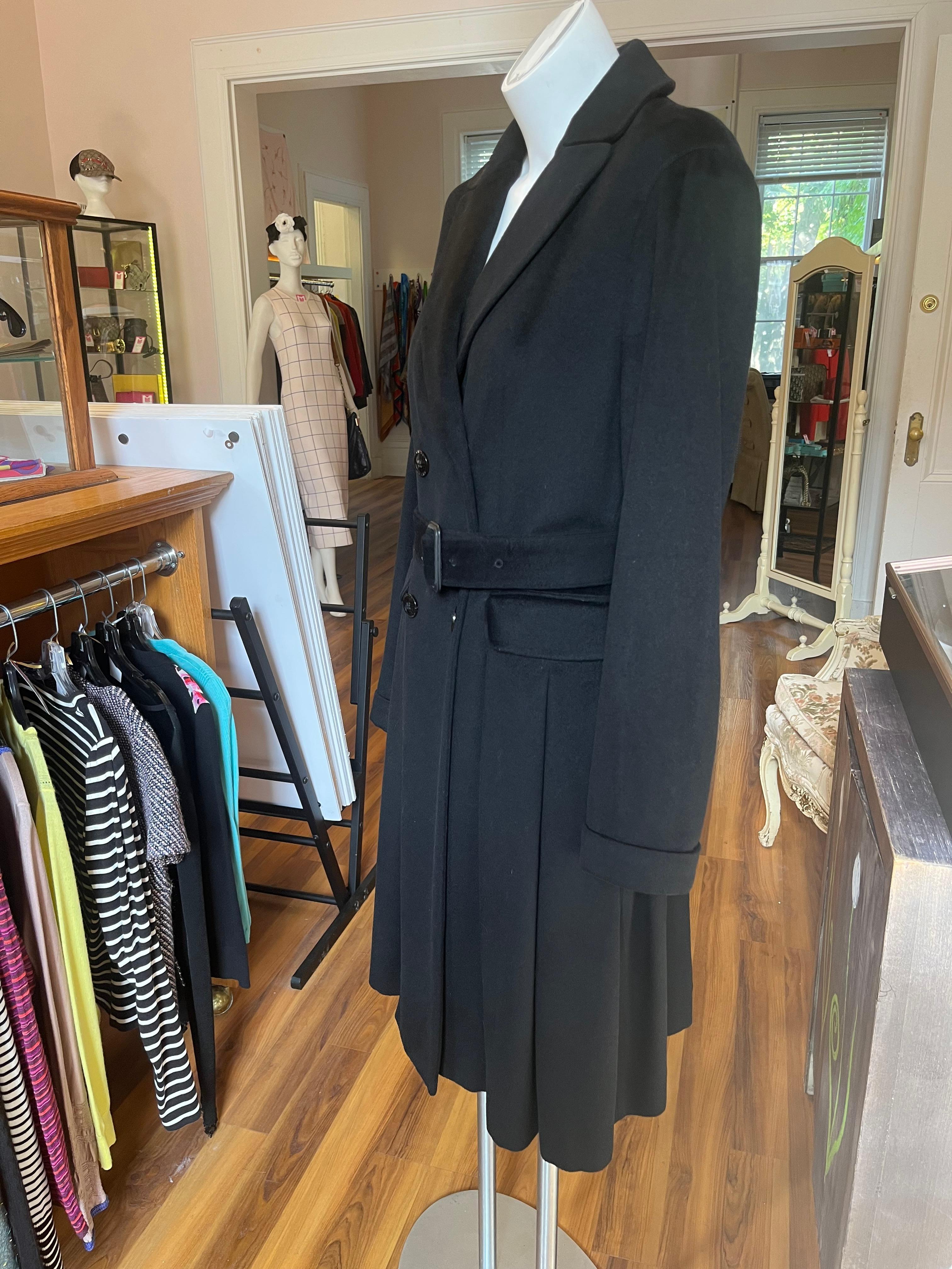 Made by Burberry's a British company well known for its high-end coats, this black wool/cashmere blend coat is beautifully tailored.
It has a notched lapel; adjustable belt; four Burberry engraved buttons at the front, and one on the inside; two