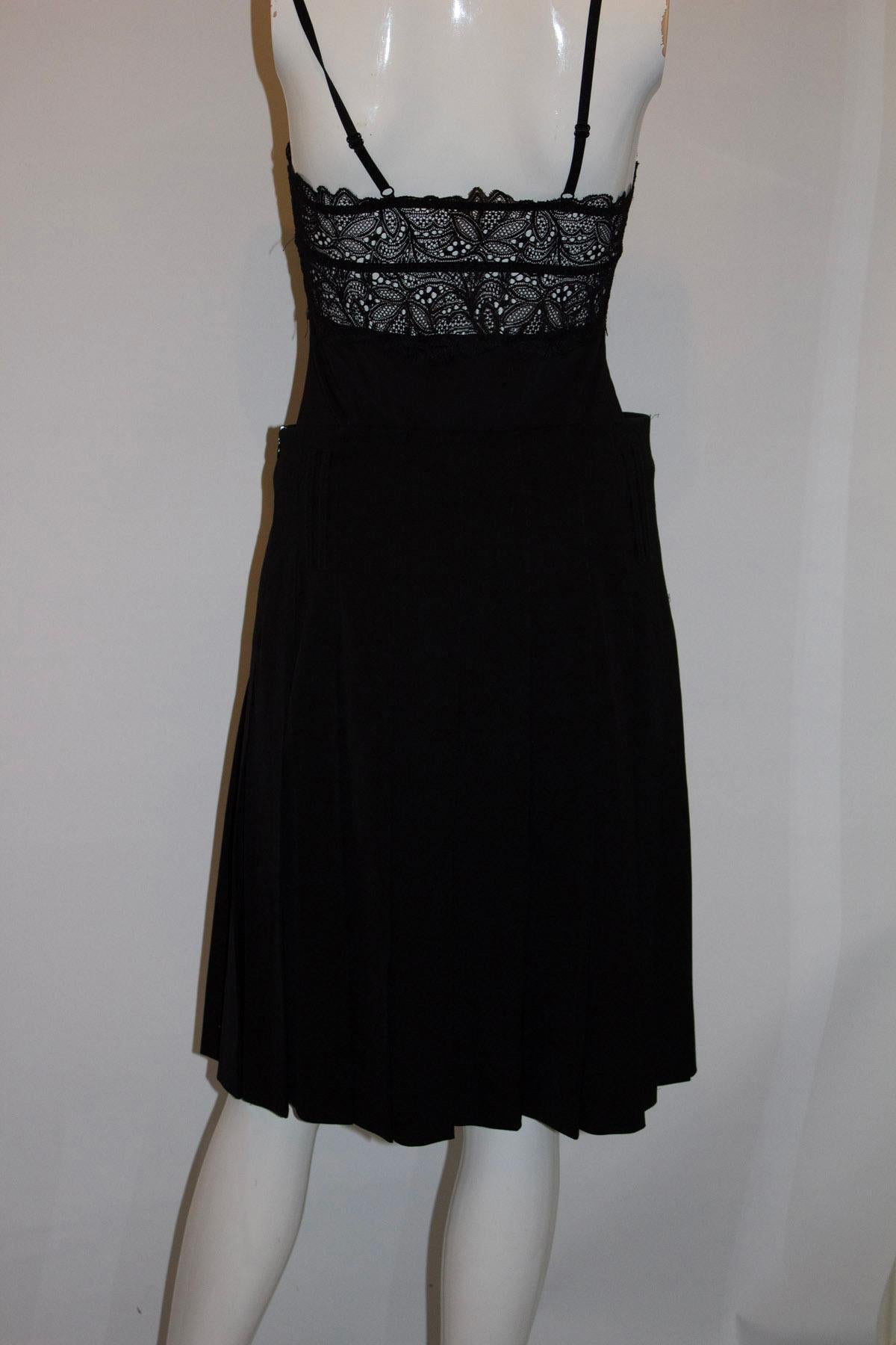 A great skirt for Fall by Burberry. In a black wool , the skirt has pleats but they are sewn down from the waist producing a smooth line. The skirt has large belt or sash hoops , a side zip opening and is fully lined.  Made in Scotland.
Size 8 