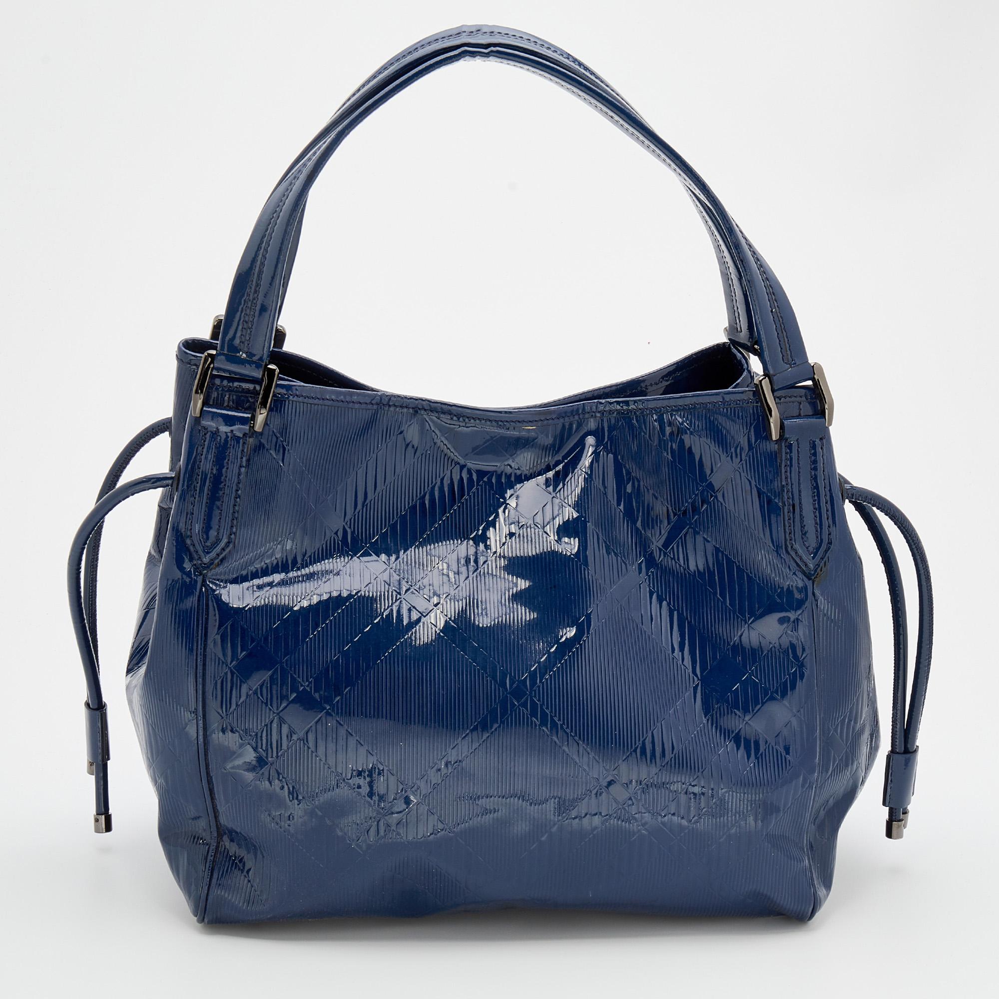 This Burberry tote promises to take you through the day with ease, whether you're at work or out and about in the city. From its look to its finish, the leather bag promises charm and durability. It has top handles and a spacious fabric interior to