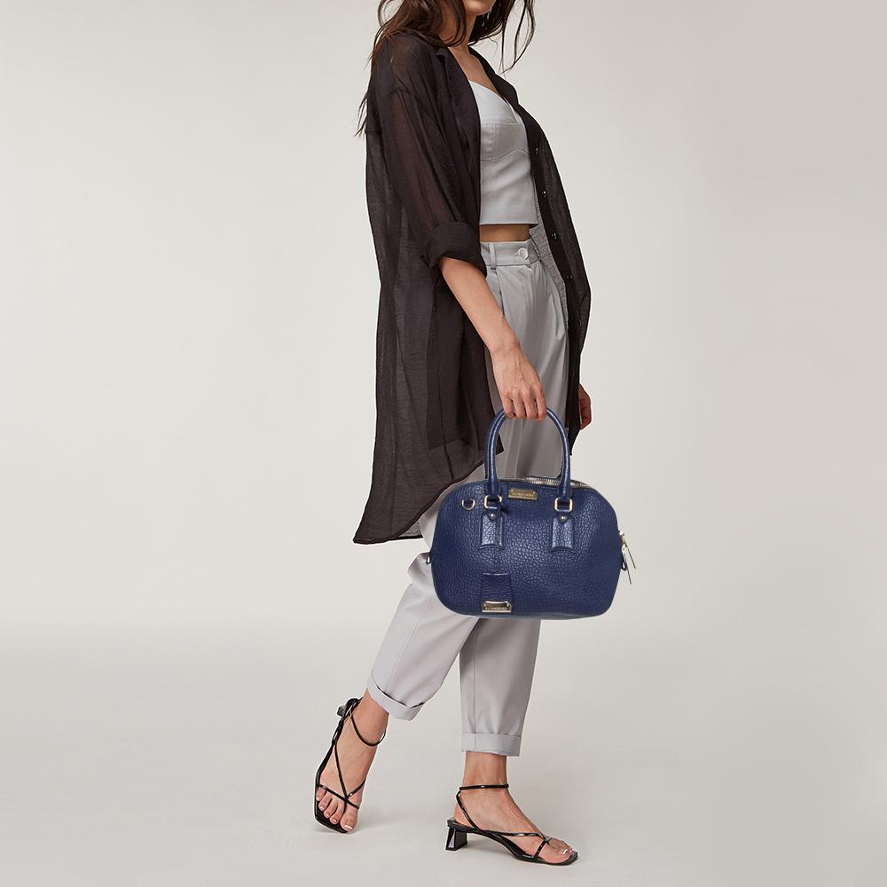 Expertly crafted and skillfully designed, this Burberry creation is a must-have in every woman's collection. It is made from grained blue leather and features two handles and a spacious fabric interior. Ideal for any day, this sophisticated bag