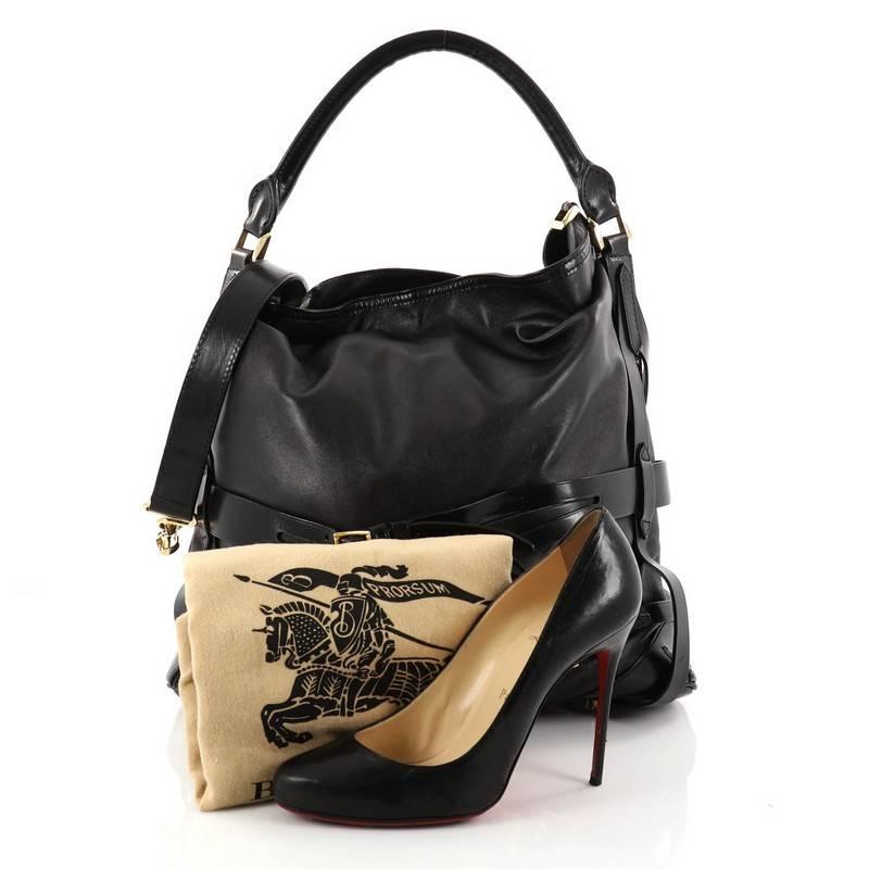 This authentic Burberry Bridle Gosford Hobo Leather Medium is a classic piece for everyday excursions. Crafted in black leather, this hobo features a single loop leather handle, multiple belted straps with buckle accents, protective base studs and