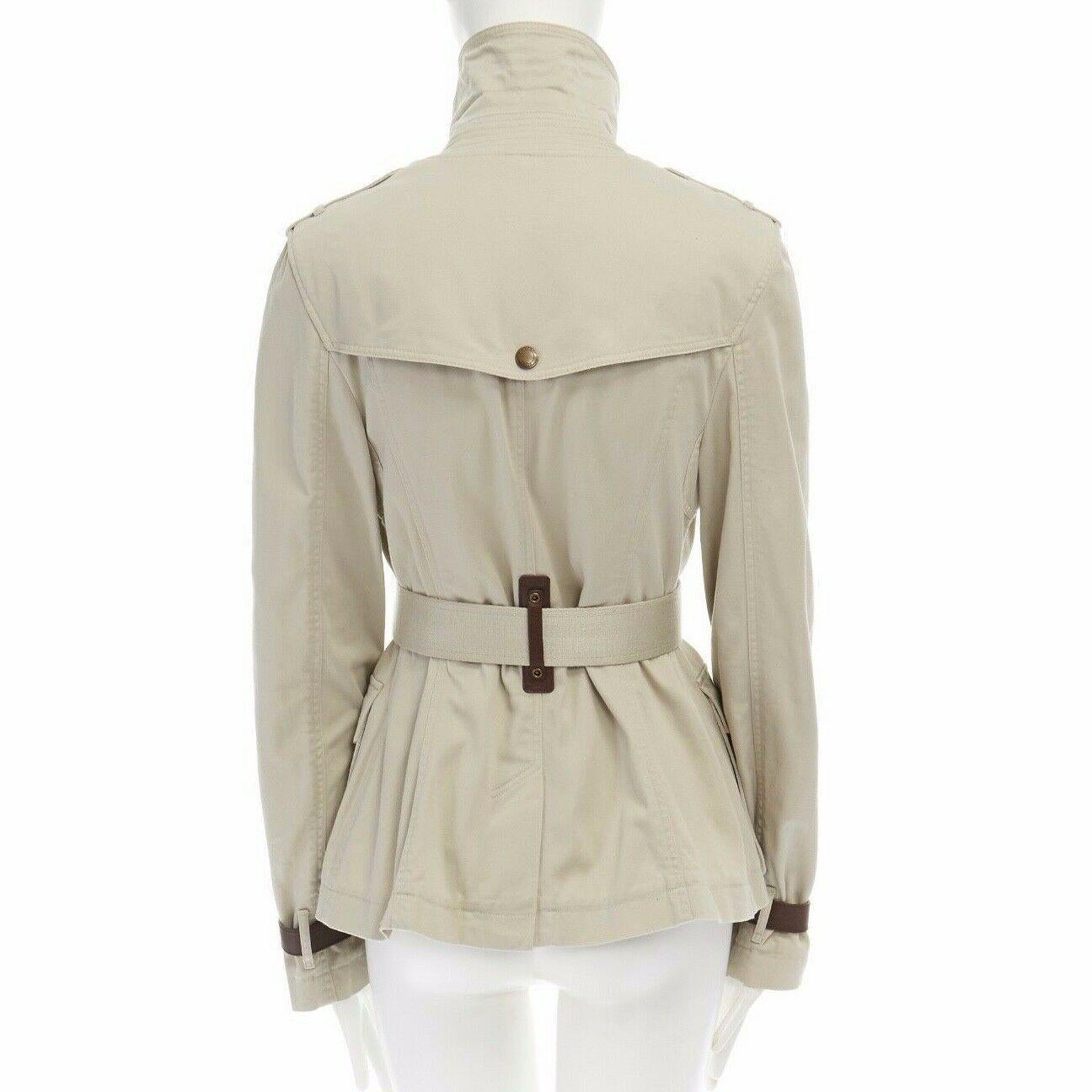 BURBERRY BRIT beige cotton leather trimmed belted safari trench field jacket M

BURBERRY BRIT
Cotton, leather. Beige cotton body. Stand collar with brown leather strap detail at collar. Gold-tone buckle signed Burberry. Zip front closure. Leather