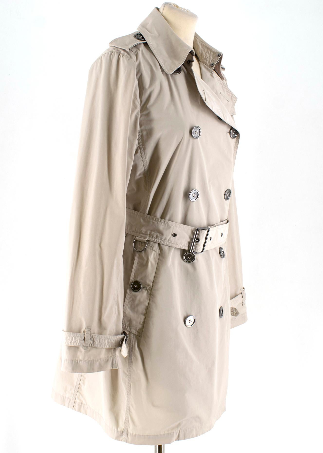 Burberry Beige Double-breasted Trench Coat 

Double-breasted trench coat in beige

Features: 
- Belted cuffs
- D-ring belt
- Silver hardware
- Burberry check under collar 

Approx: 

Length: 85 cm 
Chest: 45 cm 
Shoulder length: 40 cm 
Measurements