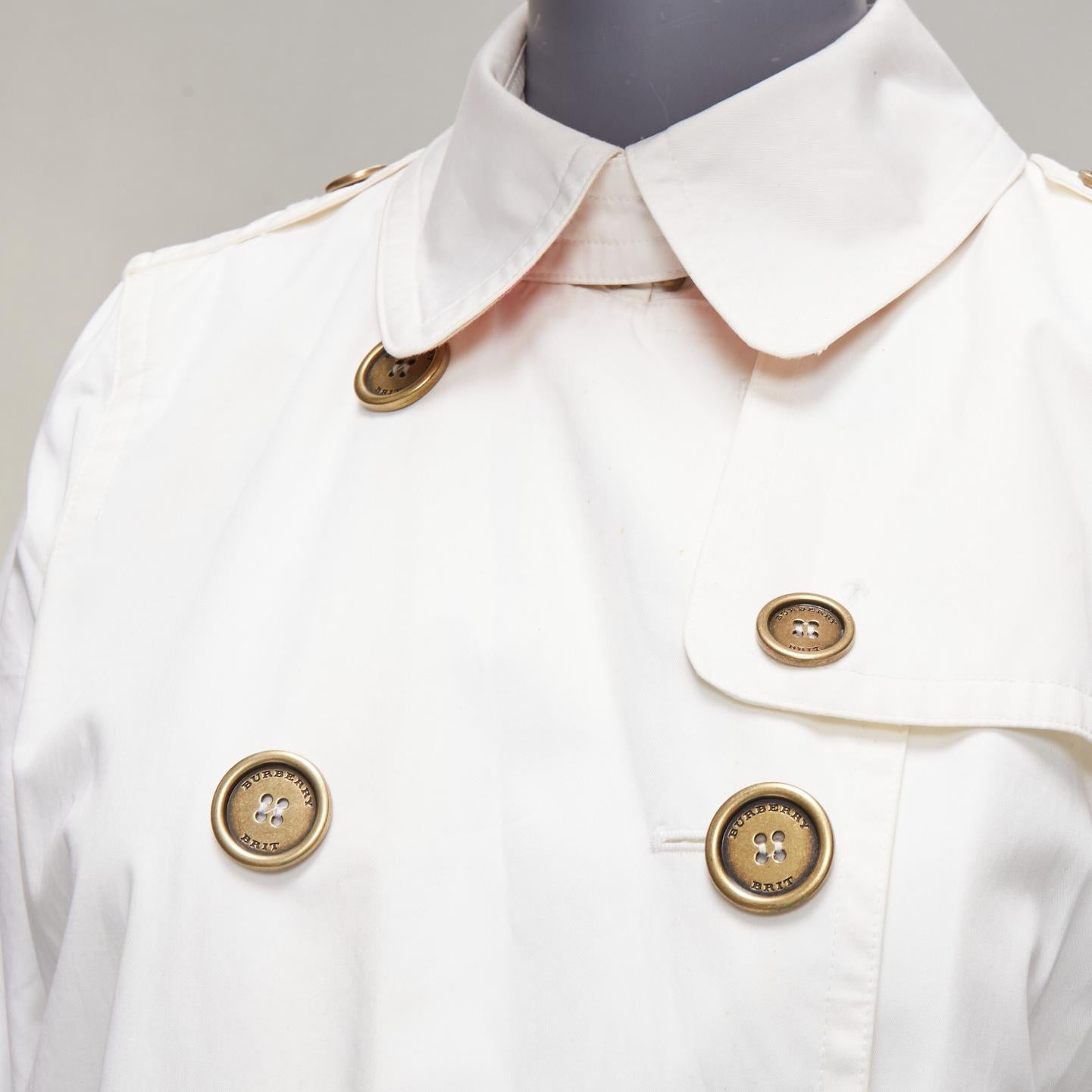 BURBERRY BRIT cream cotton metal logo buttons short trench coat UK10 M
Reference: CNPG/A00057
Brand: Burberry
Collection: Brit
Material: Cotton
Color: Cream, Gold
Pattern: Solid
Closure: Button
Made in: China

CONDITION:
Condition: Fair, this item
