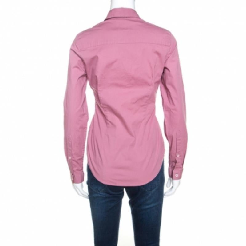 This Burberry creation comes as a classic shirt in pink. It is made with a cotton blend that is comfortable and breathable. It features front button closures, cuffed sleeves, a simple collar and has a good fit. The shirt can be paired with tailored