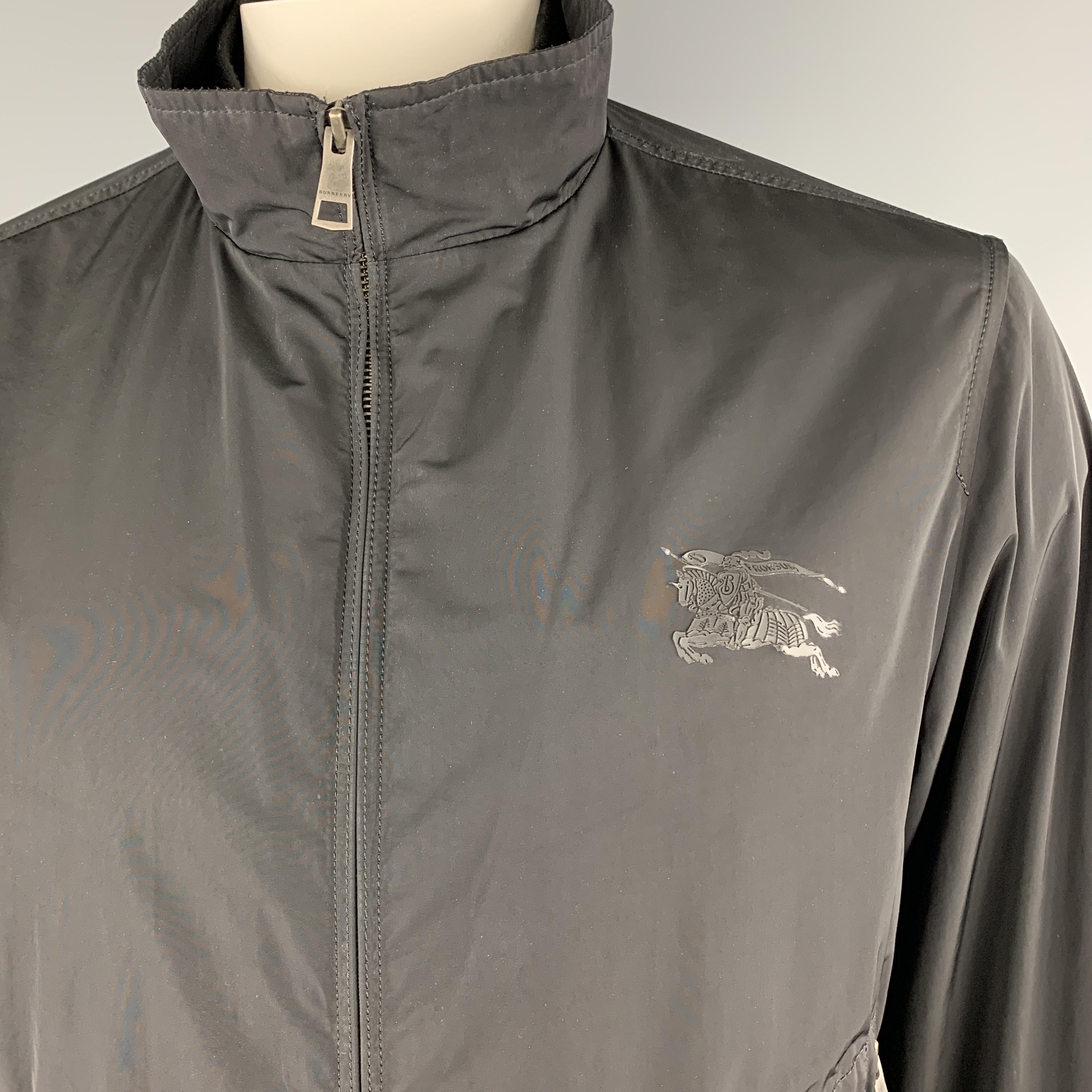 BURBERRY BRIT windbreaker jacket features a high collar with inner band, zip front, slanted zip pockets, under arm vents, and logo at chest. Wear throughout. As-is. 

Good Pre-Owned Condition.
Marked: L

Measurements:

Shoulder: 18 in.
Chest: 46
