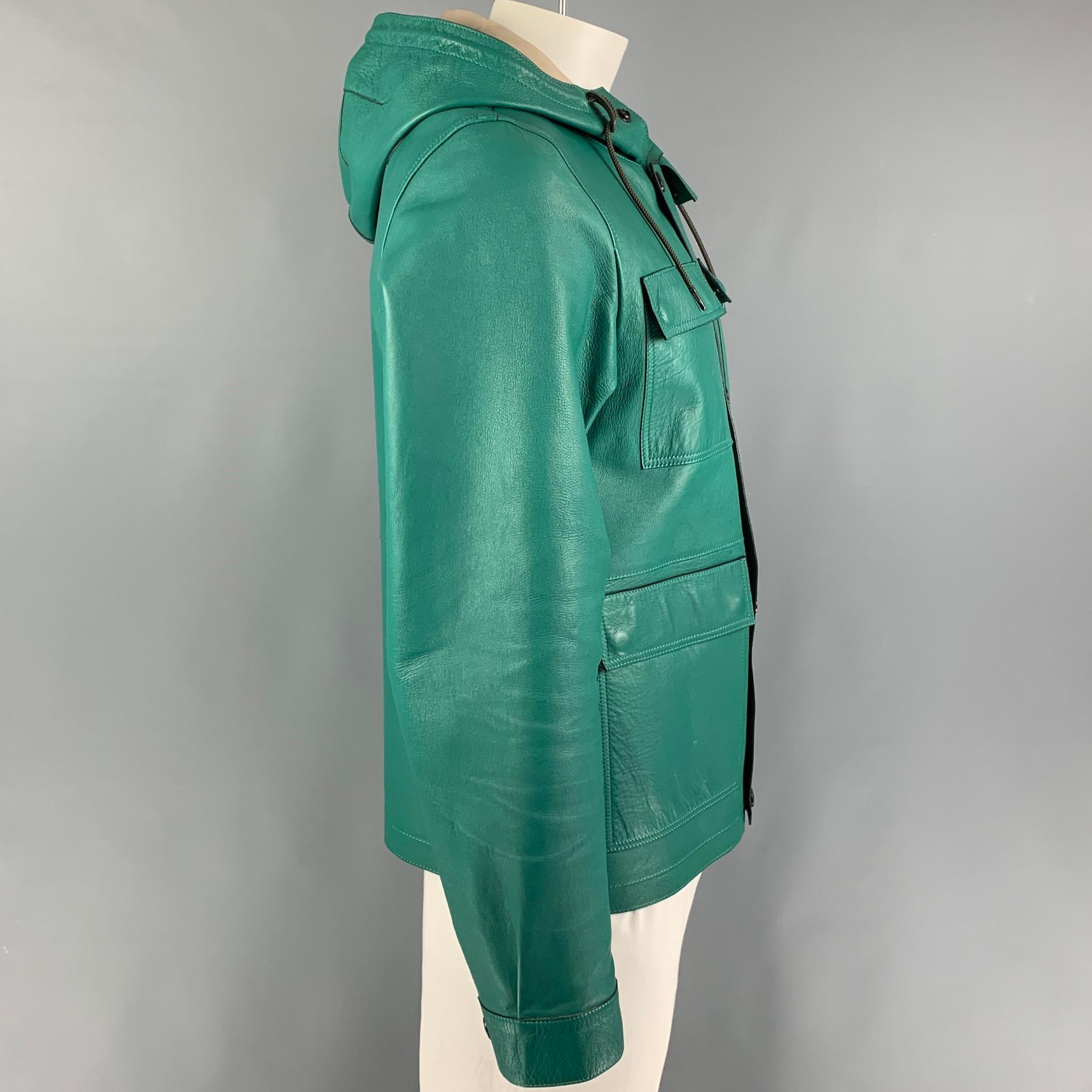 BURBERRY BRIT jacket comes in a green leather featuring a hooded design, flap pockets, drawstring, top stitching, and a zip & snap button closure. 

Very Good Pre-Owned Condition.
Marked: L

Measurements:

Shoulder: 18 in.
Chest: 42 in.
Sleeve: 26.5