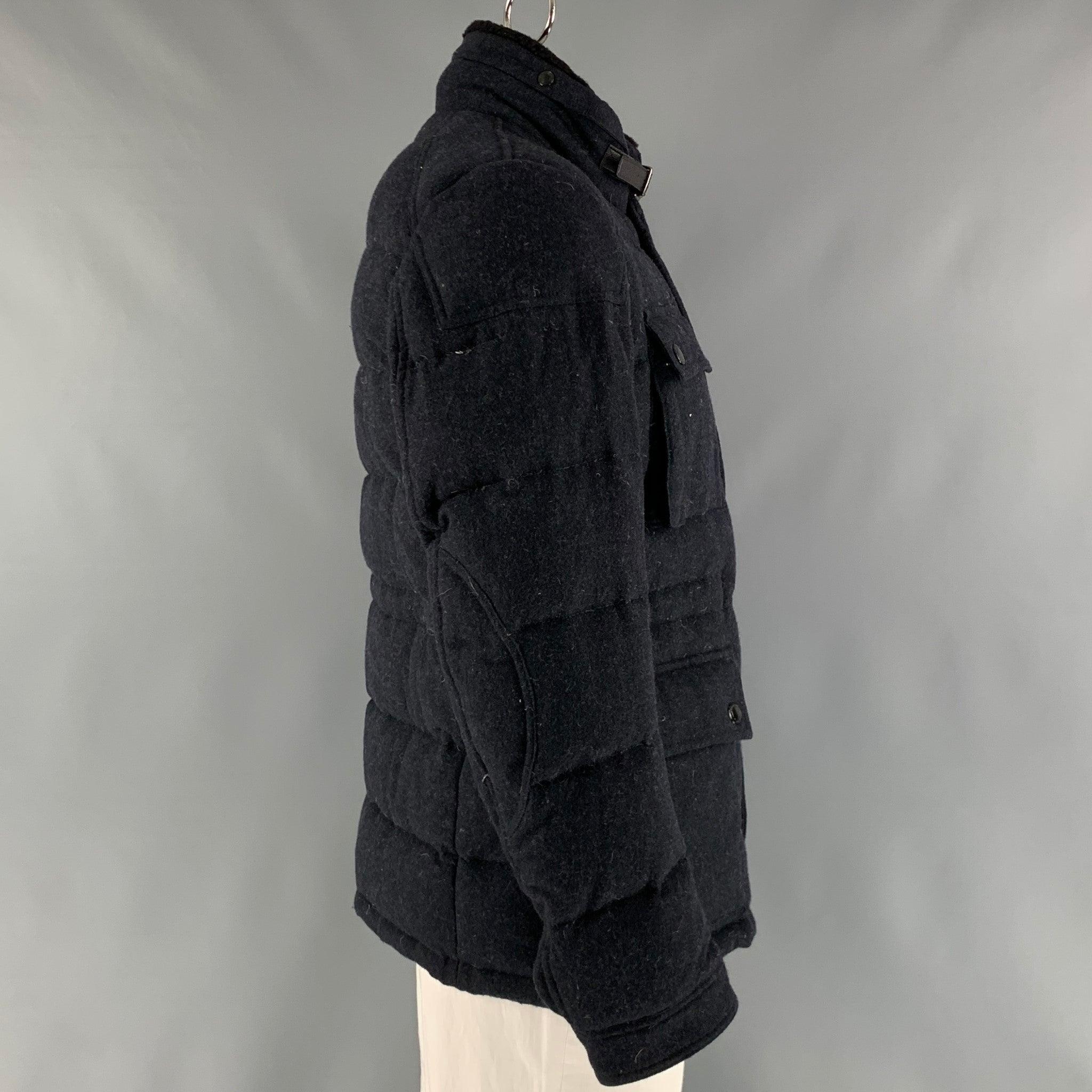 BURBERRY BRIT coat comes in a navy wool and polyamide fleece material with a plaid lining featuring a quilted style, detachable collar, flap pockets, and a 
zip up closure. Very Good Pre-Owned Condition. Minor mark at left back shoulder. 

Marked:  