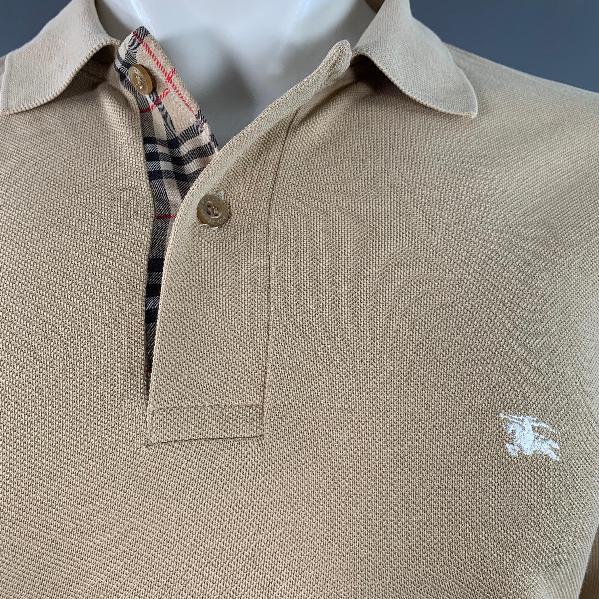 Polo BRIT de Burberry
en piqué de coton beige, avec logo brodé en blanc, bordures écossaises signature et manches longues.
Bon état d'origine. Légères bouloches, petits trous sur l'épaule. 

Marqué :   M 

Mesures : 
 
Épaule : 17.5 pouces Poitrine