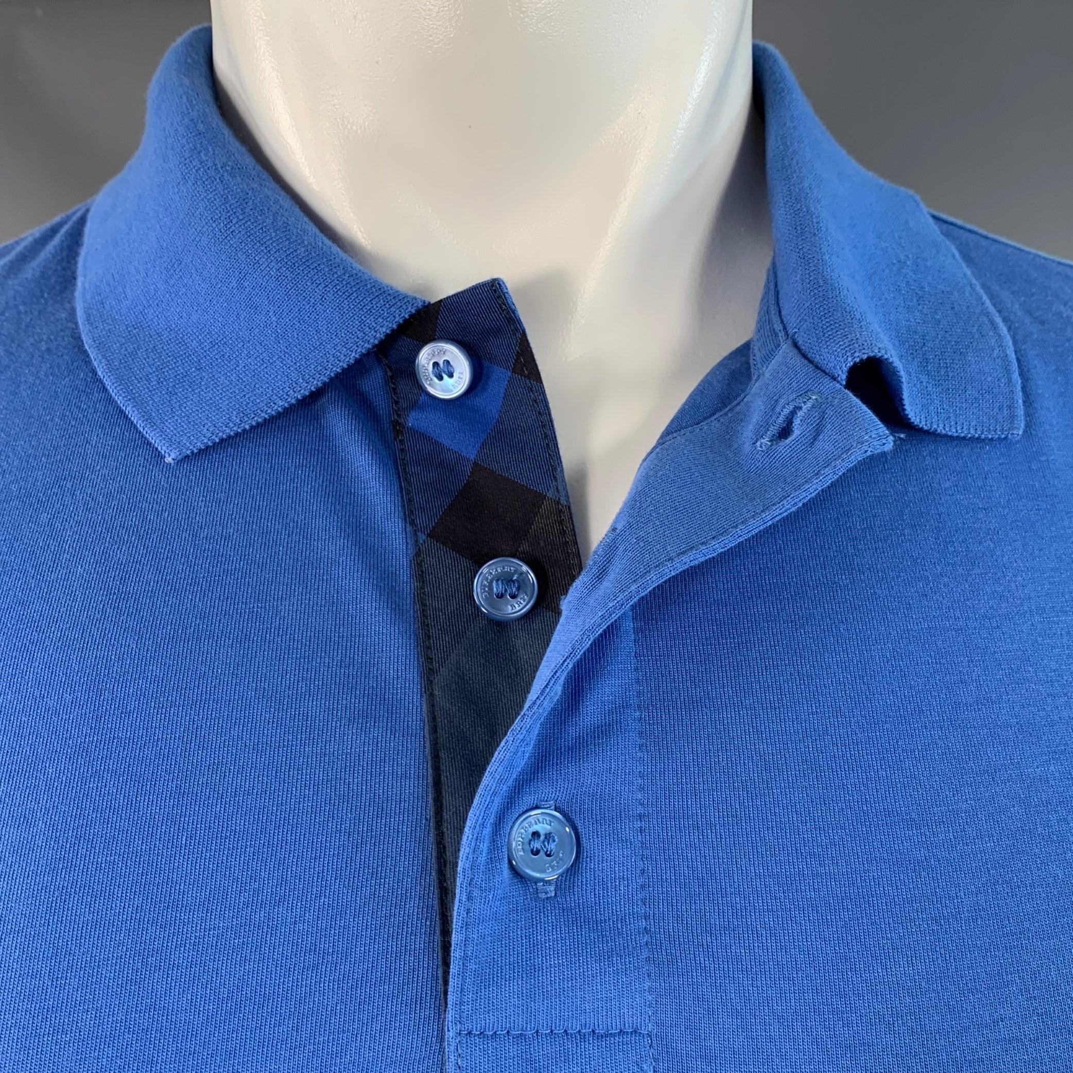 Polo BURBERRY BRIT
de punto de algodón azul, con mangas cortas y media tapeta abotonada. Muy buen estado de conservación. Pequeña marca en el lateral. 

Marcado:   M 

Medidas: 
 
Hombro 16,5 pulgadas Pecho: 39 pulgadas Manga: 8,5 pulgadas Longitud: