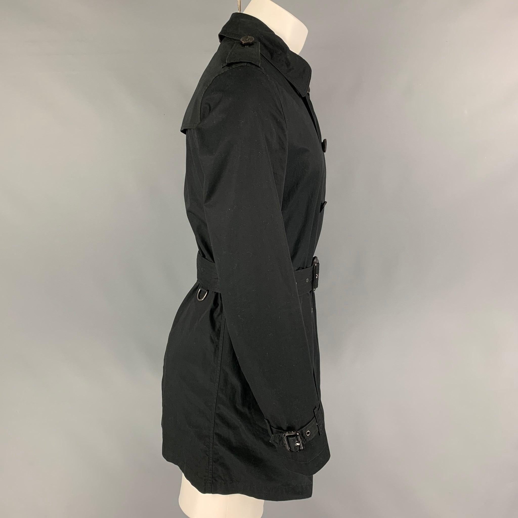 BURBERRY BRIT trench coat comes in a black cotton with a plaid liner featuring a belted style, epaulettes, front pockets, spread collar, and a zip up closure.
Very Good
Pre-Owned Condition. 

Marked:   S 

Measurements: 
 
Shoulder: 17.5 inches 