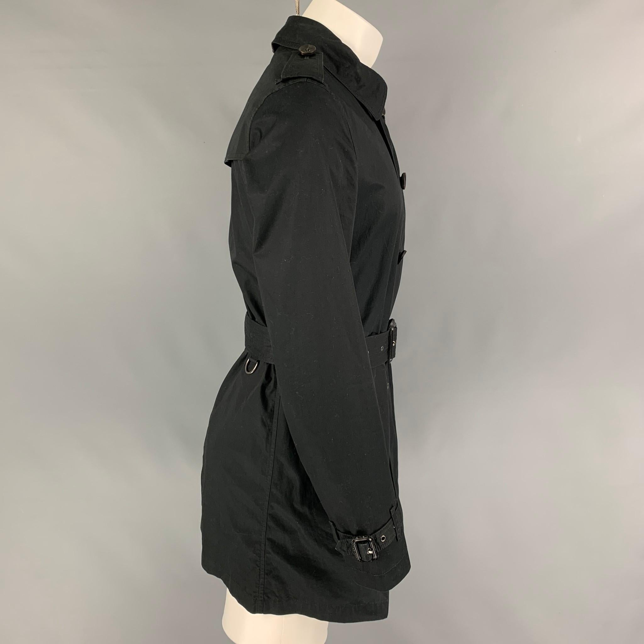 BURBERRY BRIT trench coat comes in a black cotton with a plaid liner featuring a belted style, epaulettes, front pockets, spread collar, and a zip up closure. 

Very Good Pre-Owned Condition.
Marked: S

Measurements:

Shoulder: 17.5 in.
Chest: 38