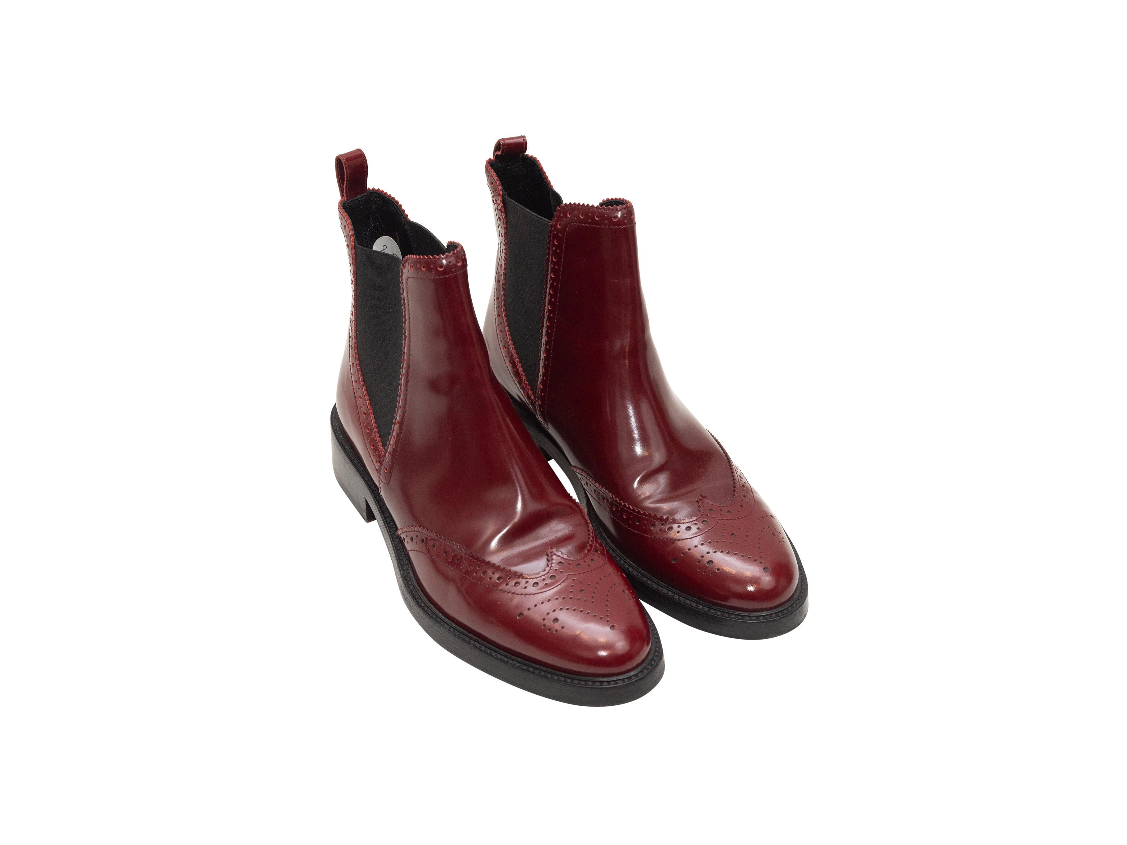 Product details: Maroon leather brogue ankle boots by Burberry. Elasticized gores at sides. Stacked heels. Designer size 38.5. 1.5