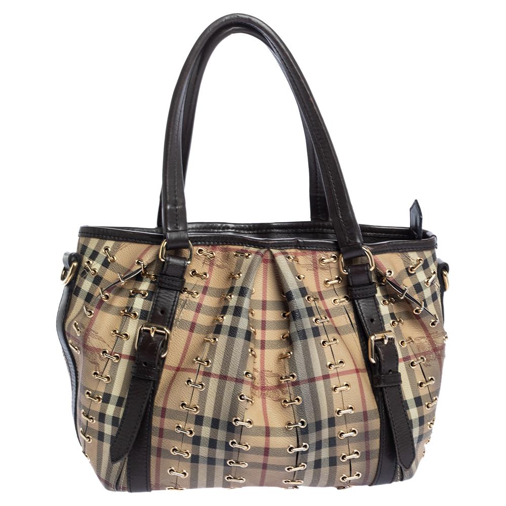 An impeccable bag that calls out to the contemporary woman in you, this Burberry creation is quite trendy. It is crafted from PVC in the brand's signature Haymarket check and styled with leather straps and dual top handles. It is detailed with
