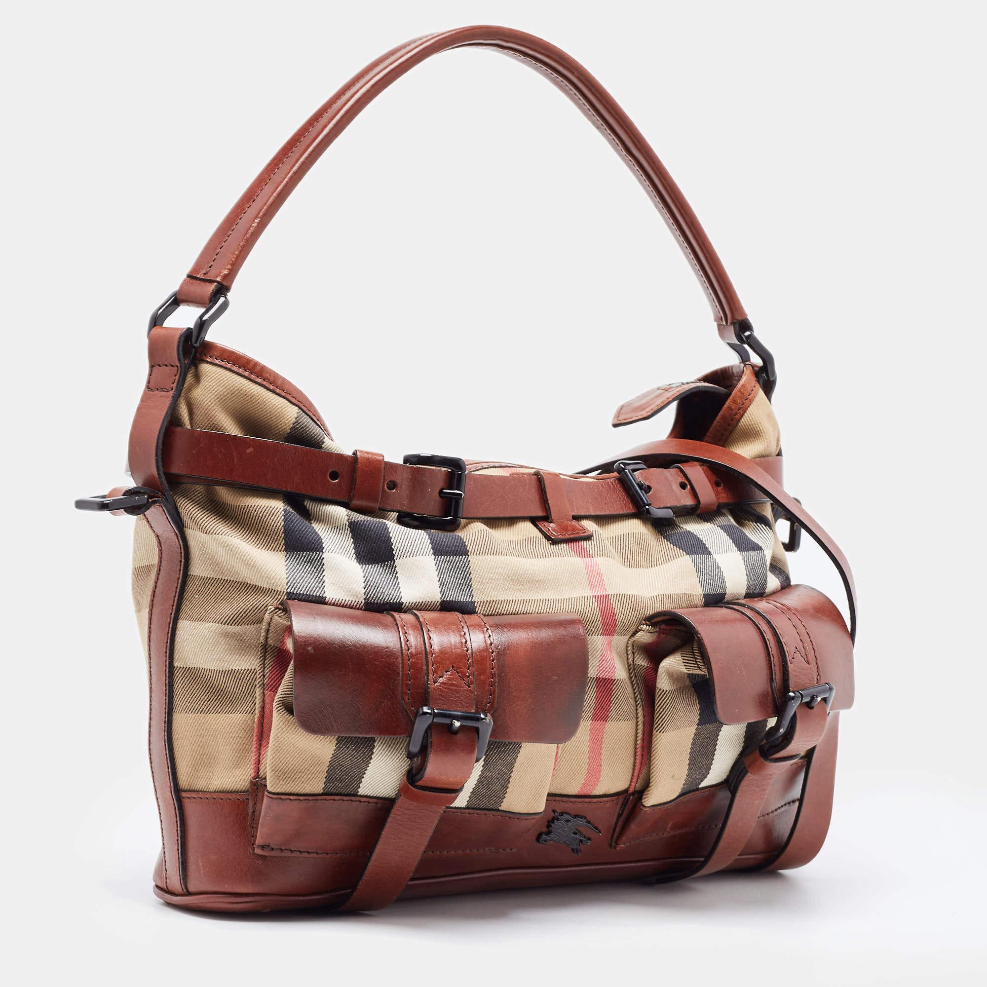 A fine handbag by Burberry that's perfect to use from workday to the weekend. Made from House Check canvas and brown leather, the hobo flaunts a single top handle, a shoulder strap, and black-tone hardware. The interior is lined with fabric and