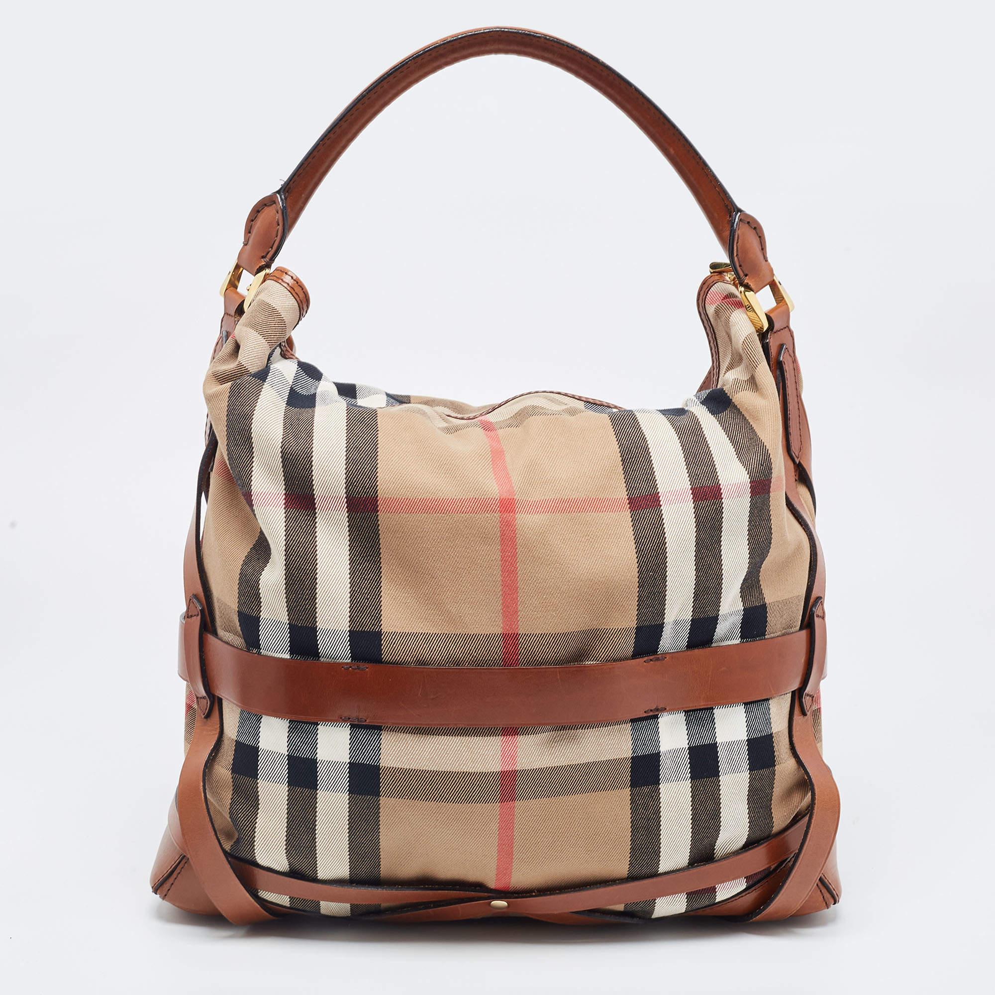 This Bridle Gosford hobo from Burberry might just be your next favorite bag! It is both high in style and is functional enough to accompany you on all days. It is made from beige-brown House Check canvas and leather, paired with gold-tone hardware.

