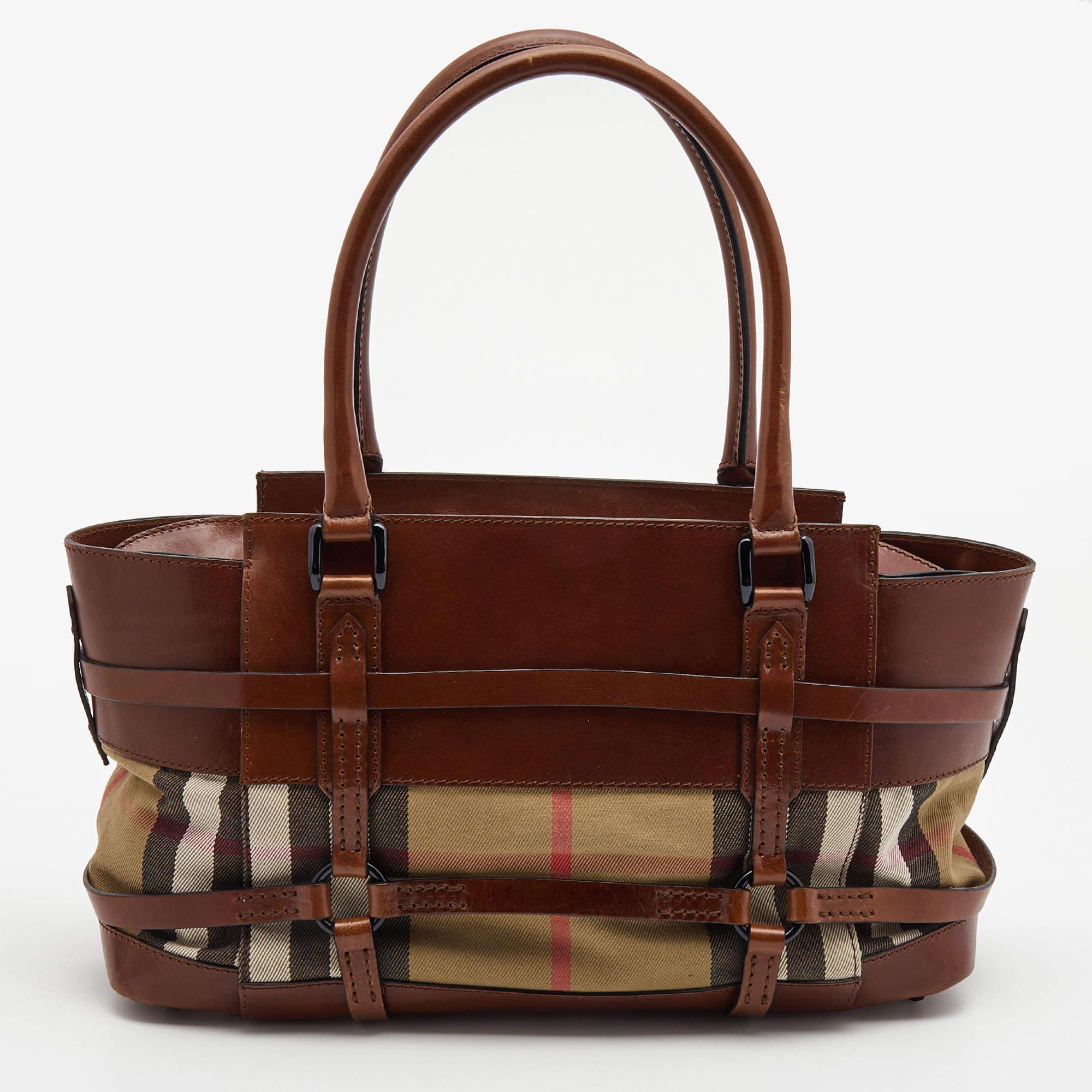 The simple silhouette and the use of durable materials for the exterior bring out the appeal of this Burberry satchel for women. It features comfortable handles and a well-lined interior.

