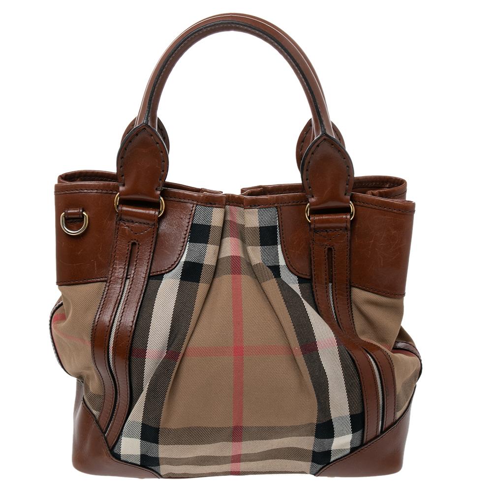 This stylish and functional tote bag from the iconic house of Burberry is a closet must-have. Crafted in Italy, this Bridle tote bag has been made from the brand's House check canvas and leather. It flaunts lovely beige and brown hues. The exterior