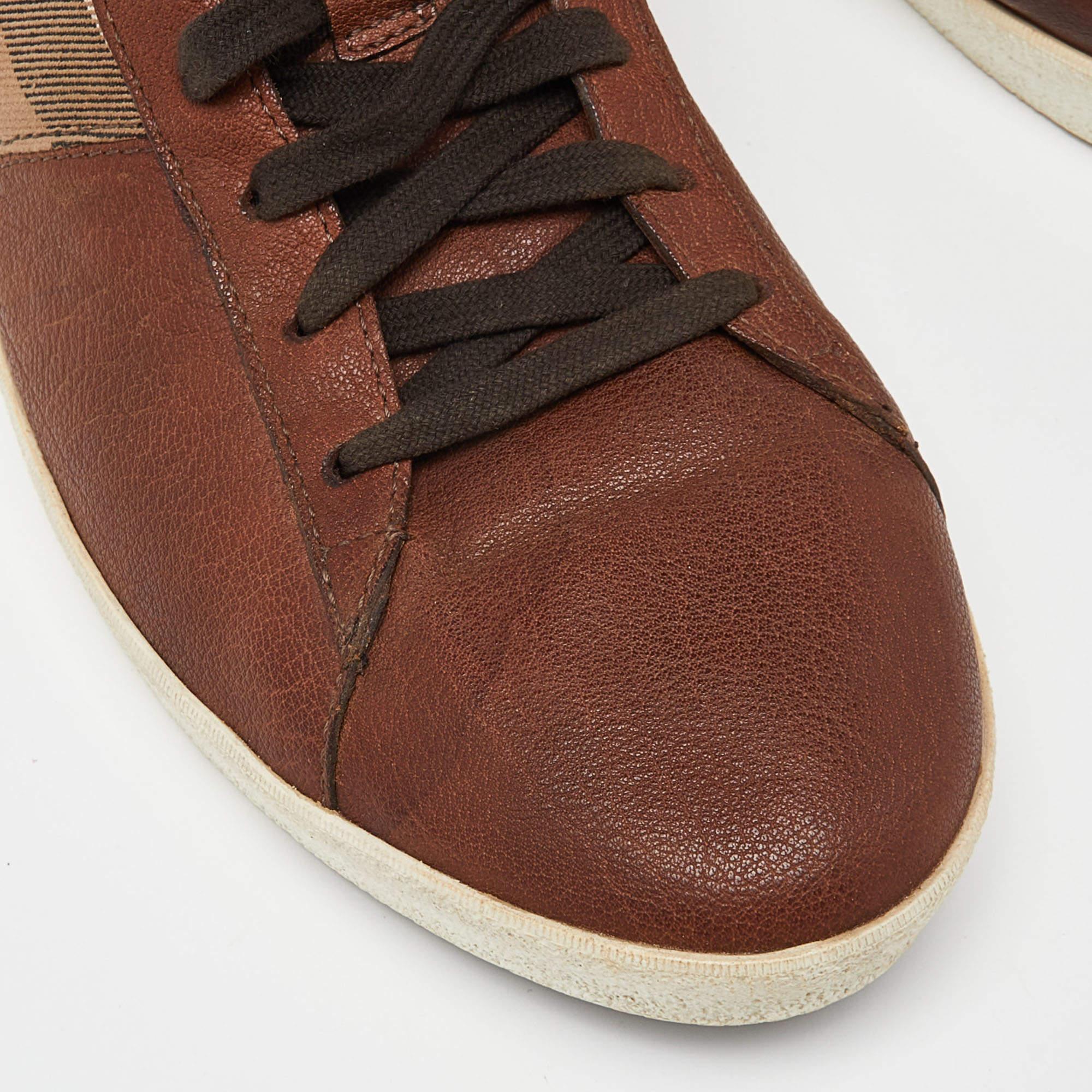 A simple high-top leather design is updated with Burberry's iconic check canvas to form these luxe sneakers for men. Set on a durable rubber sole, this pair is secured with brown laces on the vamps. Style yours with smart casuals.

