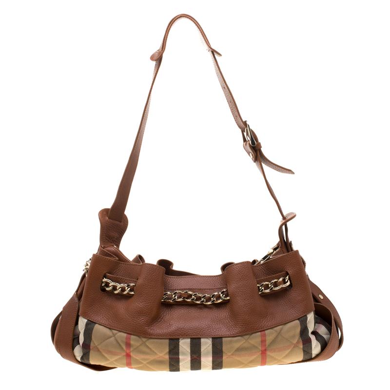 Well-made and captivating, this Margaret shoulder bag is from Burberry. It has been crafted from leather and their signature House check canvas in a quilt pattern. The bag is equipped with a well-sized fabric interior, a shoulder handle, and chain