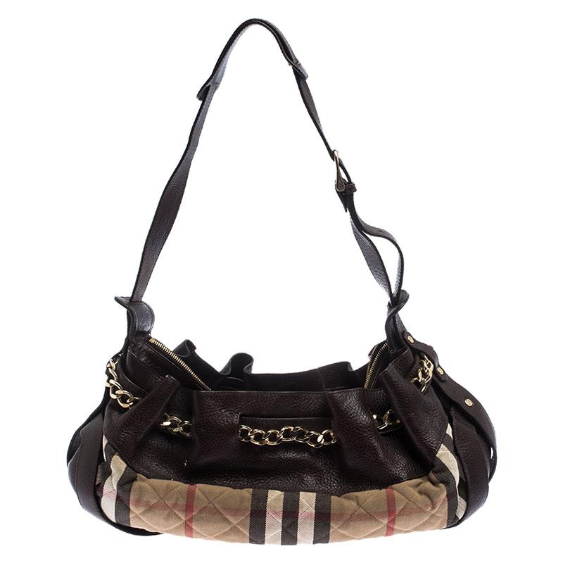 Well-made and captivating, this Margaret shoulder bag is from Burberry. It has been crafted from brown leather and their signature House check canvas in a quilted pattern. The bag is equipped with a well-sized fabric interior, a shoulder handle, and