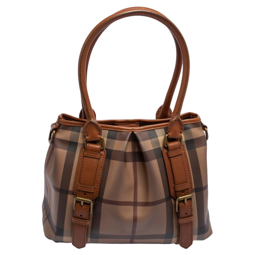 Spacious and captivating, this Northfield tote from Burberry is crafted from the signature Smoke check PVC & leather. It is equipped with two rolled handles, a detachable shoulder strap, and a well-sized canvas interior to house your belongings. The