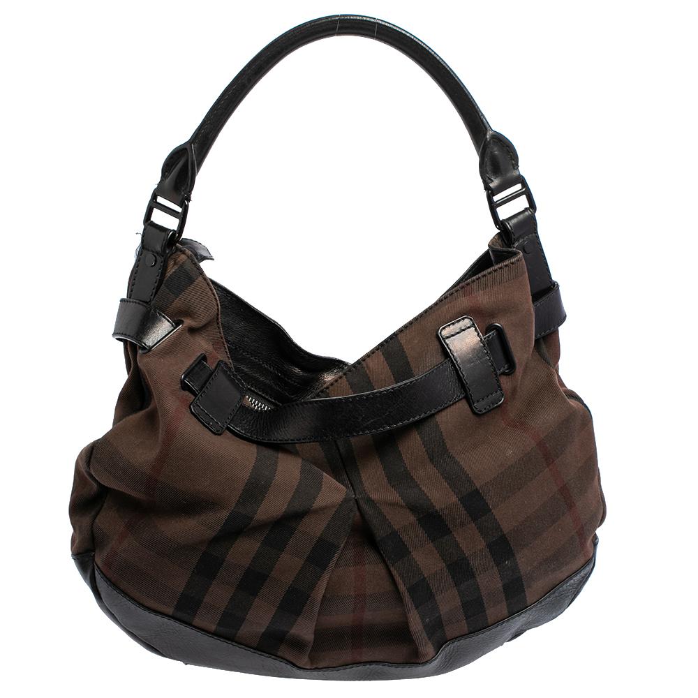 This classic hobo by Burberry has a signature look. Crafted beautifully, this bag is made of the brand's iconic Check canvas and has leather trims. The bag is held by a single handle and opens to reveal a spacious fabric-lined interior. It is a