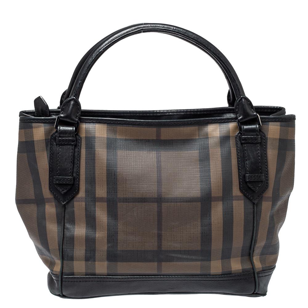 This beautifully stitched Smoke Check PVC and leather tote is by Burberry. With a capacious canvas-lined interior, it will house more than your essentials. Boasting two handles and a seamless finish, this tote offers style and utmost practicality.

