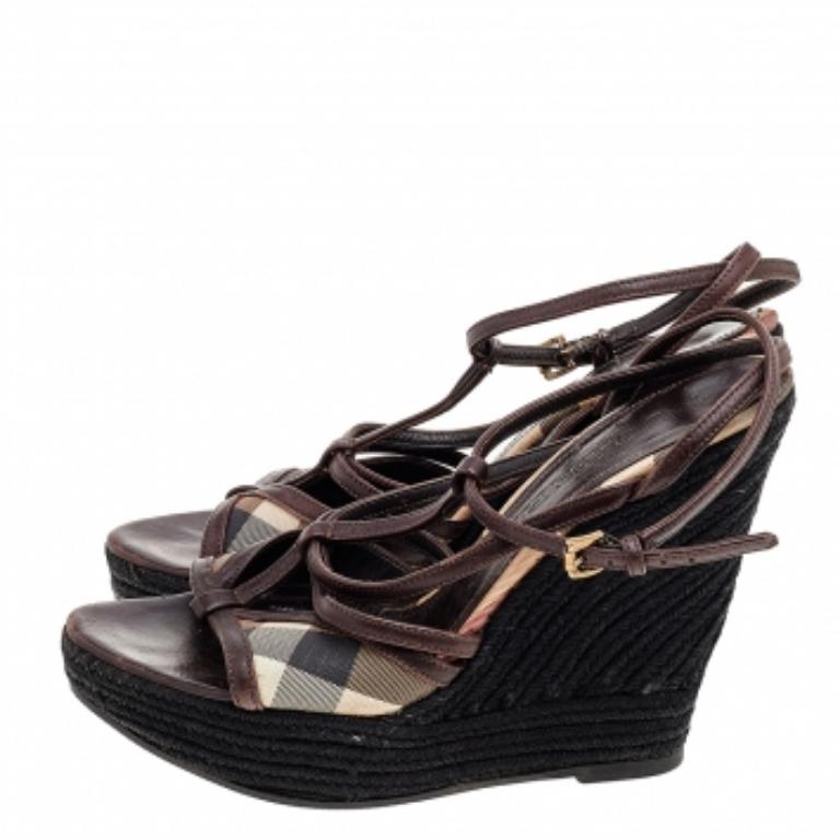 Ces sandales Burberry sont le reflet de l'art immaculé du Label en matière de cordonnerie. Confectionnées en toile et en cuir dans une teinte marron, ces beautés au charme intemporel sont dotées de brides croisées et de talons compensés soutenus par