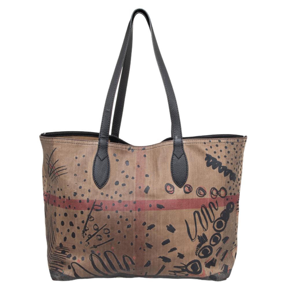 Catering to your changing moods, this Reversible tote from Burberry has been fabulously crafted in a reverse design so you can use it both ways. It comes with a checked canvas exterior along with a reversible doodle-printed interior. This tote is