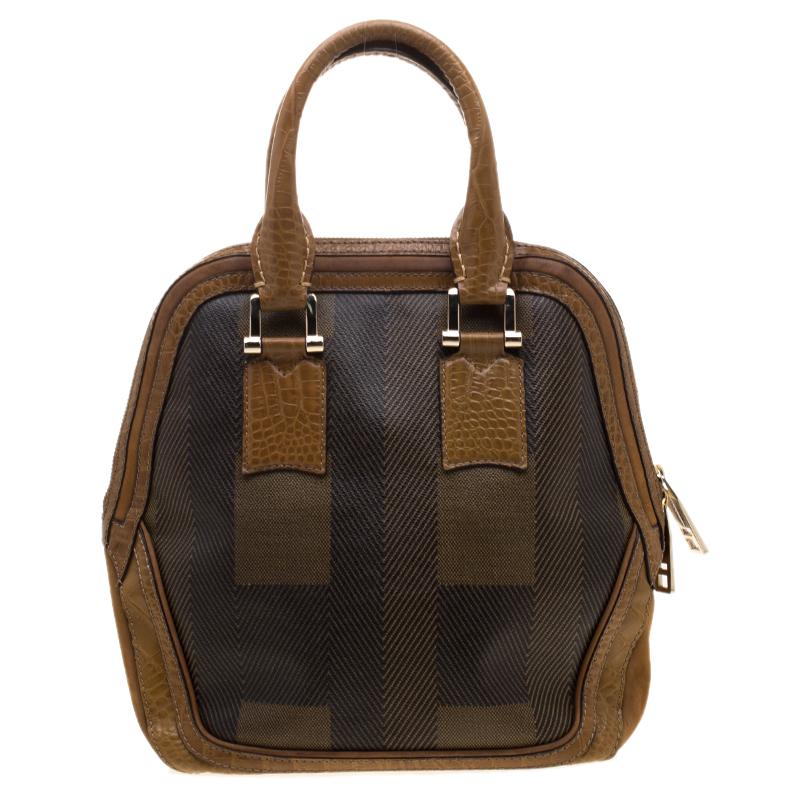 Fall in love with this absolutely dashing satchel from Burberry. This brown bag is crafted from coated canvas and leather and it comes with dual handles. The double zip closure opens to a canvas lined interior and the bag is completed with
