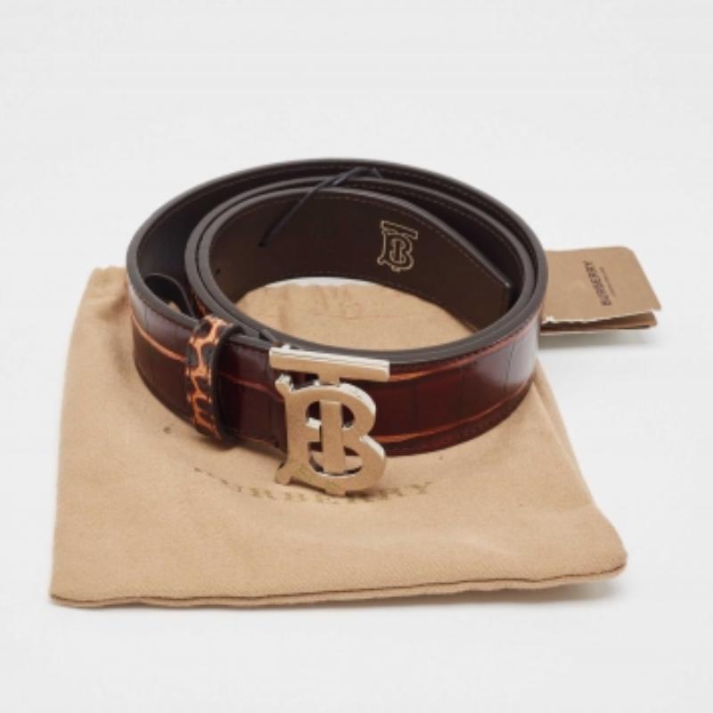 Aquí tienes un accesorio con clase que te ayudará a estar impecable. Este cinturón de Burberry eleva tu estilo y te hace parecer con clase. Este cinturón está confeccionado en piel repujada de cocodrilo con una hebilla plateada.