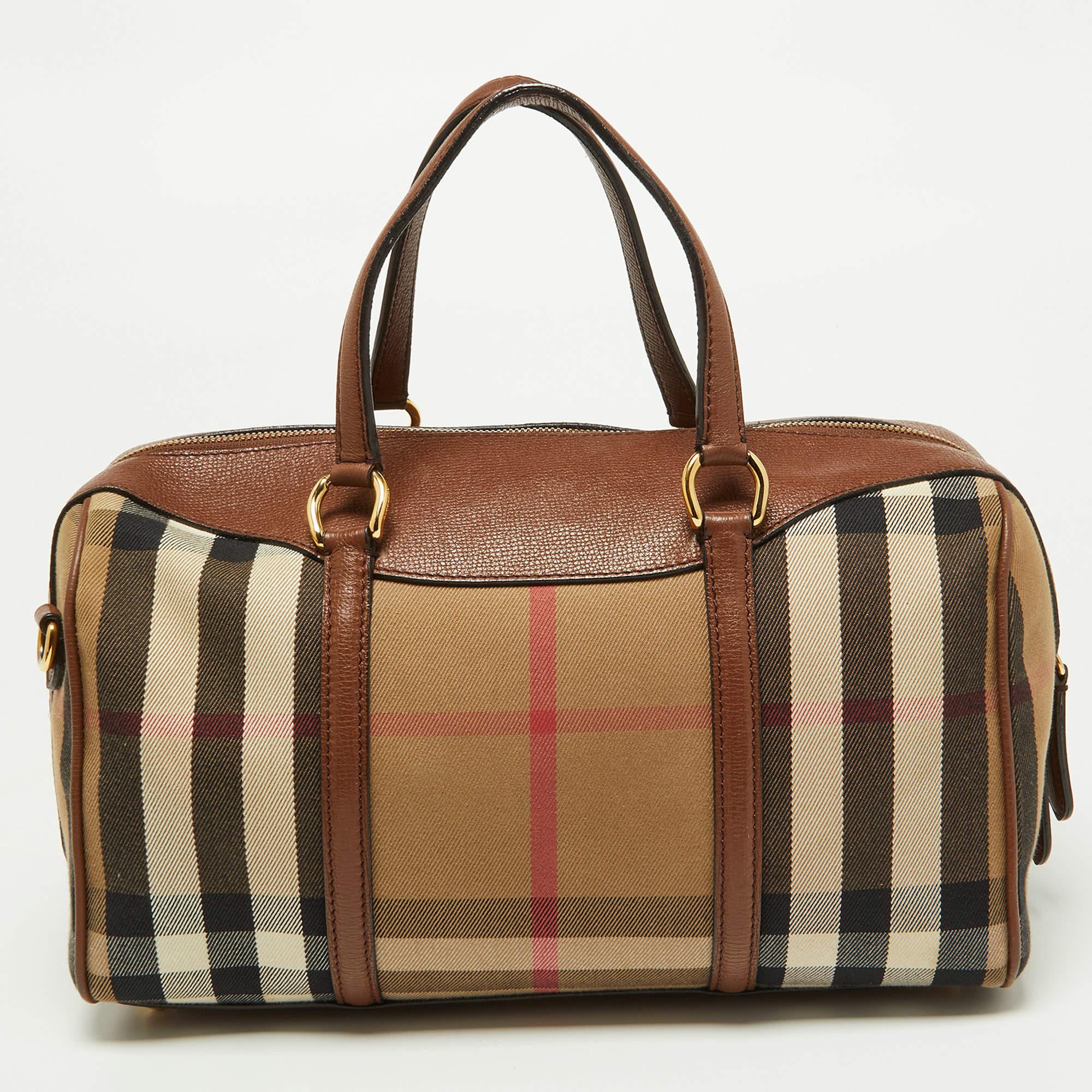 A stunning blend of autumn colors in leather & Nova check coated canvas makes this Burberry Alchester Bowler Bag an instant classic. Ideal for your everyday essentials, this barrel-shaped bag features dual handles, a removable shoulder strap, and