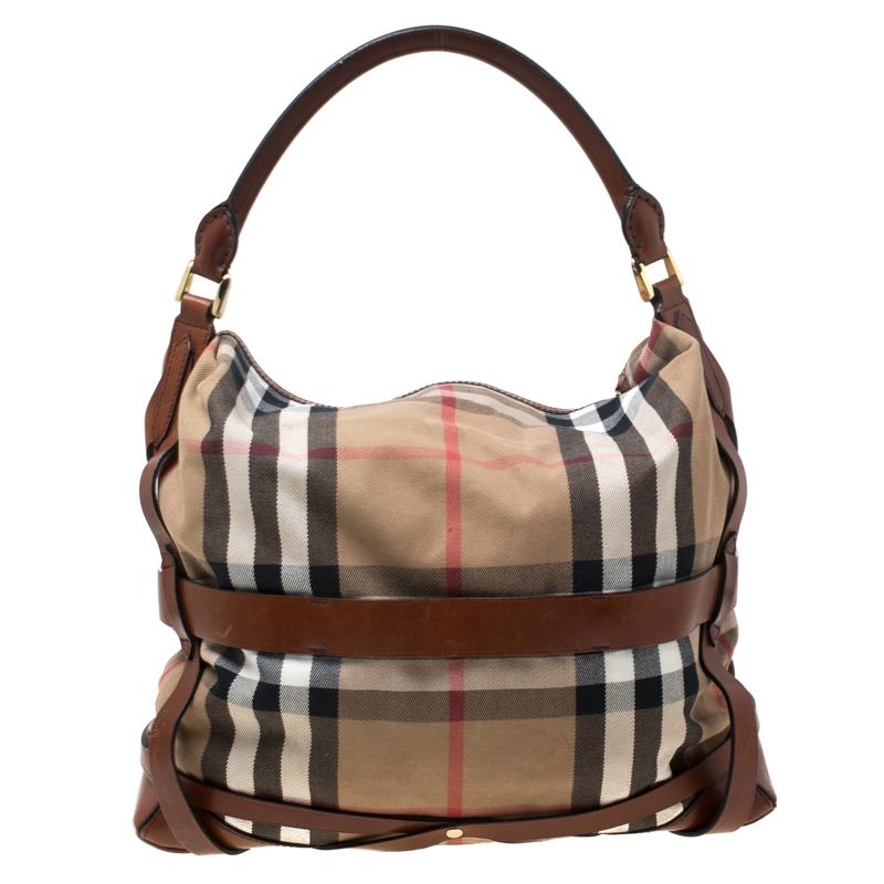 This Burberry hobo might just be your next favourite handbag. It is high in style and is functional enough to accompany you on all your busy days. The bag comes crafted with their signature House check canvas and leather, with buckle details and a