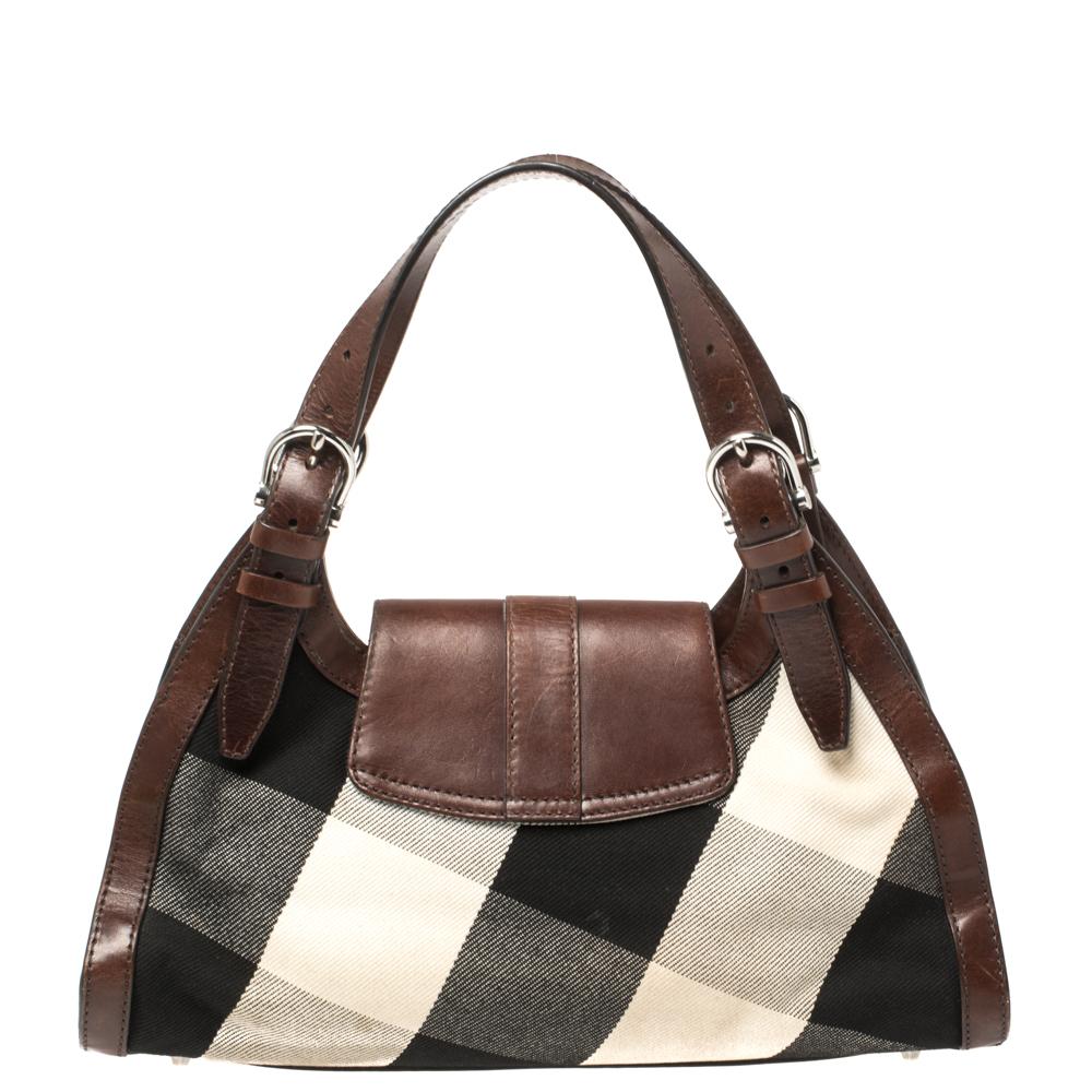 Complete a stylish look with this beautiful Burberry bag. It has a Mega Check canvas and leather exterior and a spacious canvas interior with the brand label. This bag is completed with a buckle-detailed flap. A perfect complement to all your