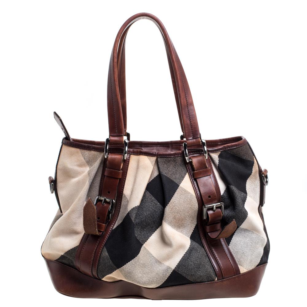Complete a stylish look with this beautiful Burberry Lowry tote. It has the iconic check-coated canvas & leather exterior and a top-zip closure that opens up to a spacious canvas interior with the brand label. This bag is completed with buckled