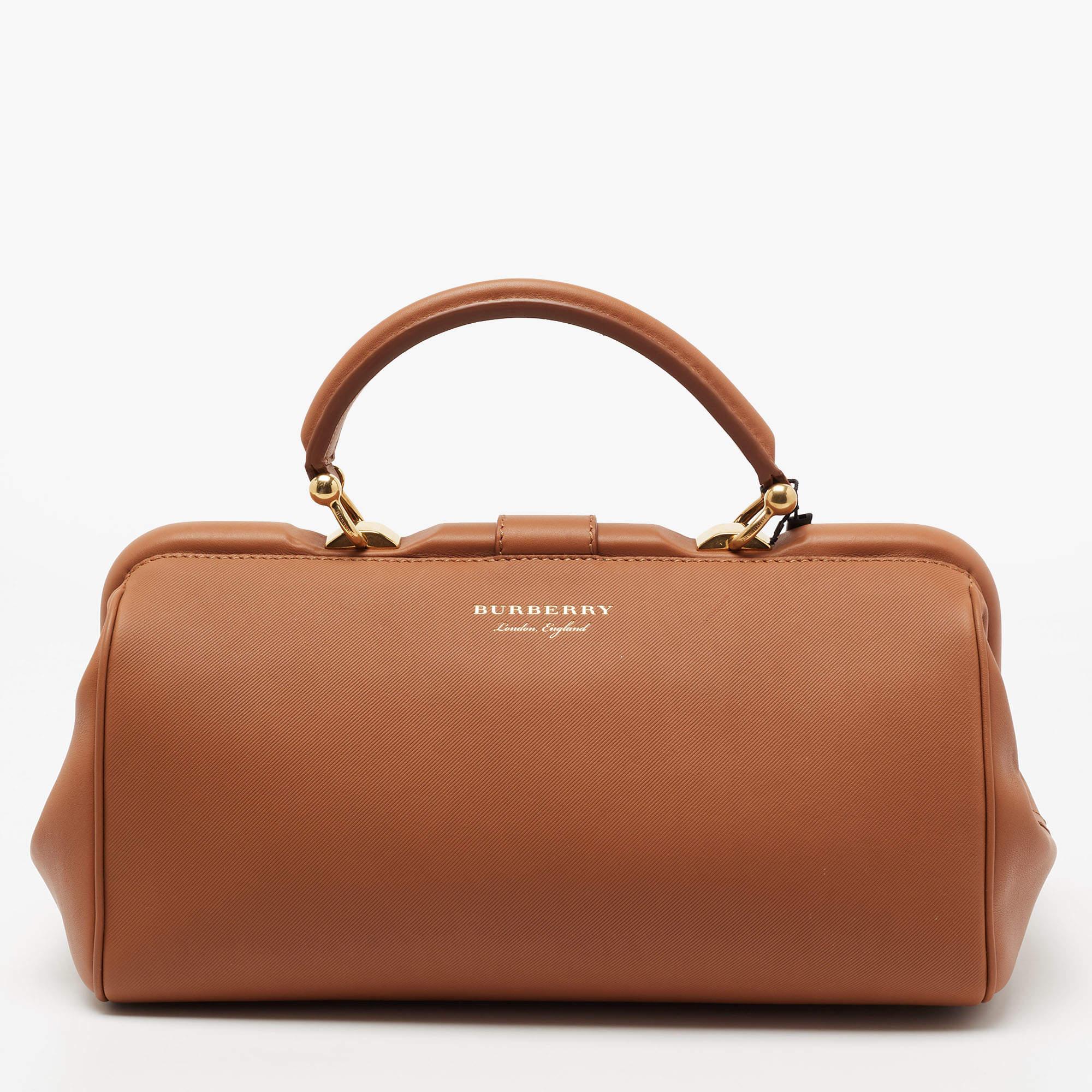 A revolutionary name in fashion, Burberry is defined by class and innovation. The minimal silhouette of this Bowling bag adds to its timeless appeal, and the striking branded lock closure on the front elevates the design. Lined with Alcantara, it