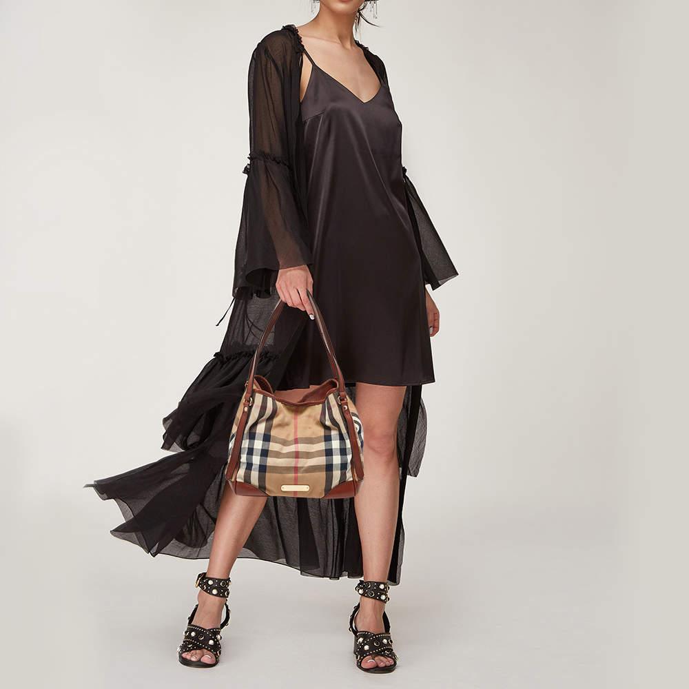 This Canterbury tote from Burberry is crafted from the signature Check canvas and enhanced with leather. It comes with dual handles protective metal feet and a spacious canvas lined interior that can hold all your daily necessities. Simple in design