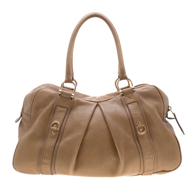 The fashion house of Burberry brings you yet another stunning creation with this hobo bag crafted from brown leather. Lined with their signature check fabric, it features gold-tone hardware, two rolled handles, and a zip closure that houses